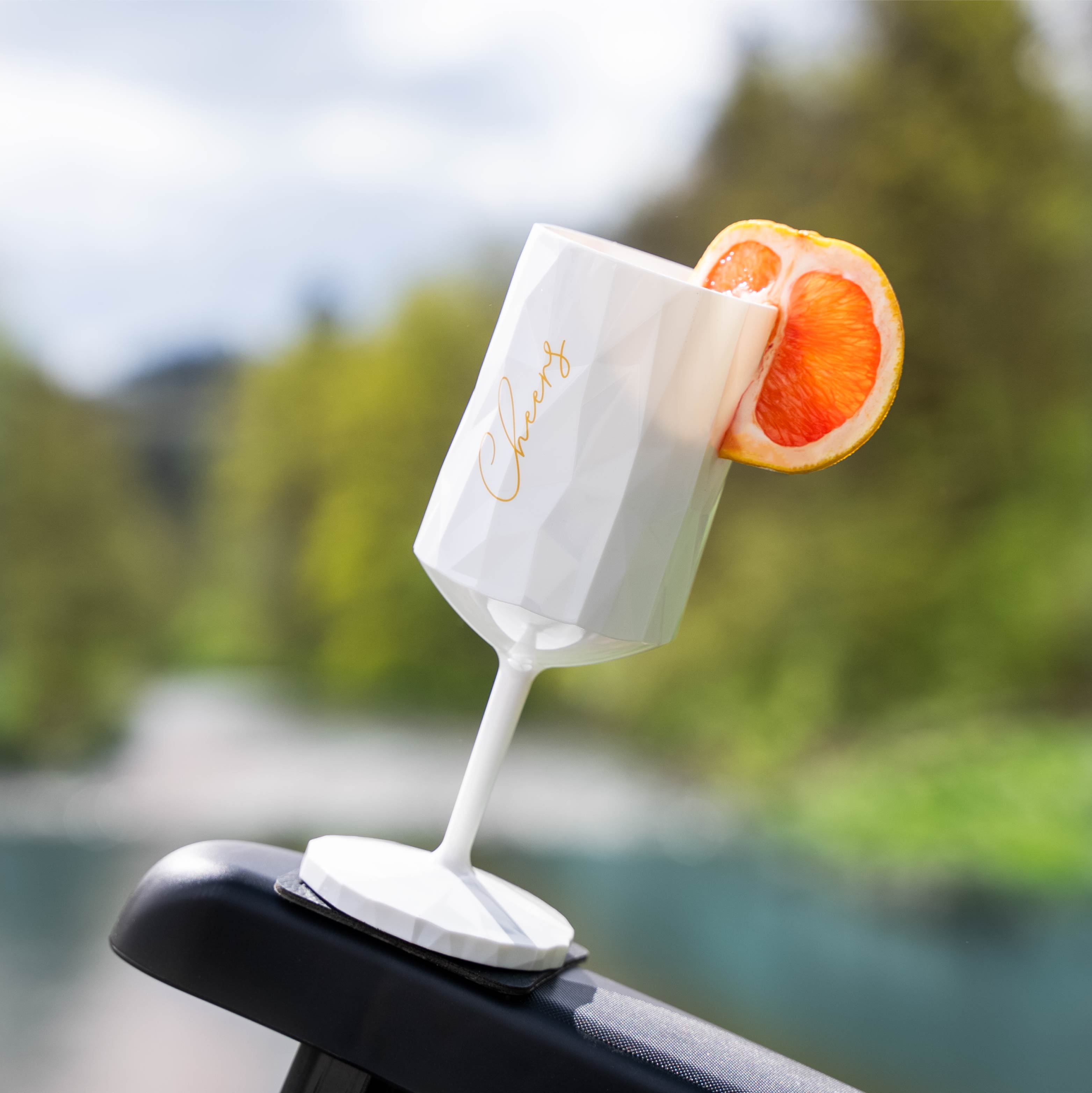 Kunststoffglas mit Magnet fixiert auf Armlehne eines Campingstuhls mit Pad