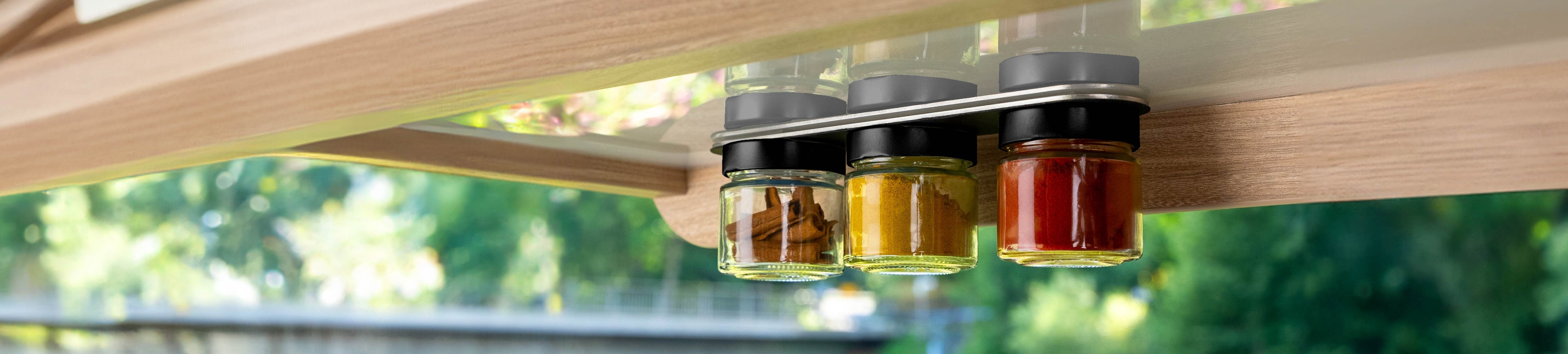 Magnet-Feinkostgläser hängend an der Metall-Leiste im Camper