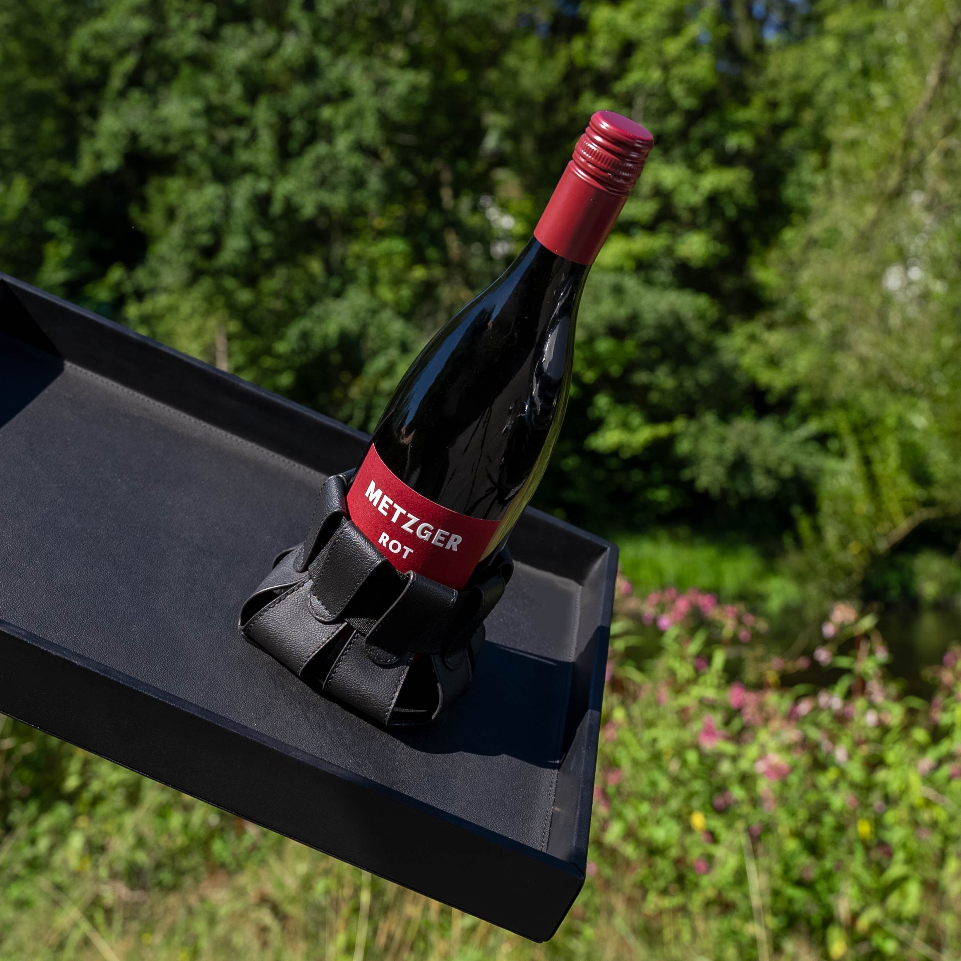 Flasche Rotwein in Magnet-Flaschenhalter auf Metall-Tablett