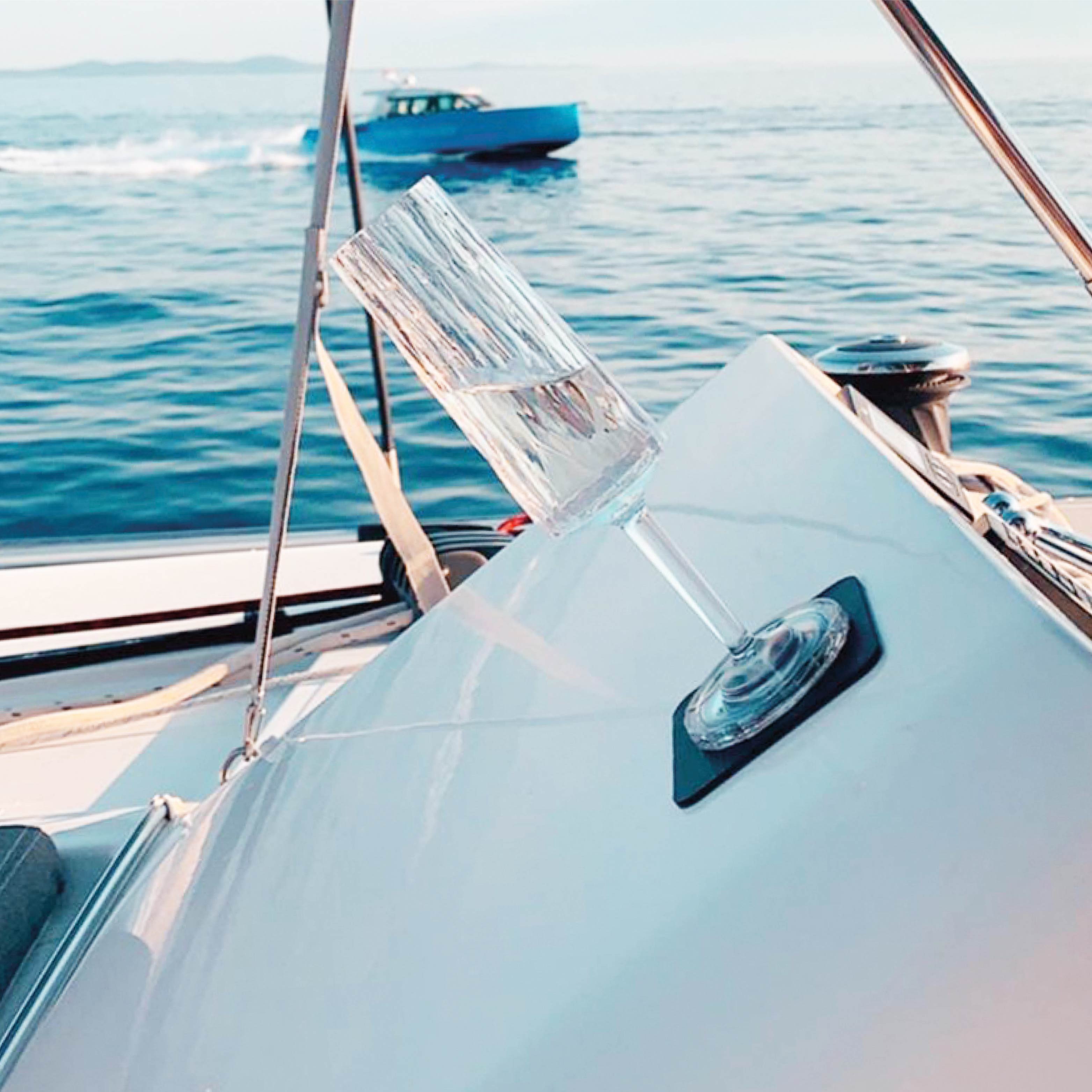 Magnet-Kunststoffglas Sekt fixiert auf einem Pad in Schräglage auf einem Boot