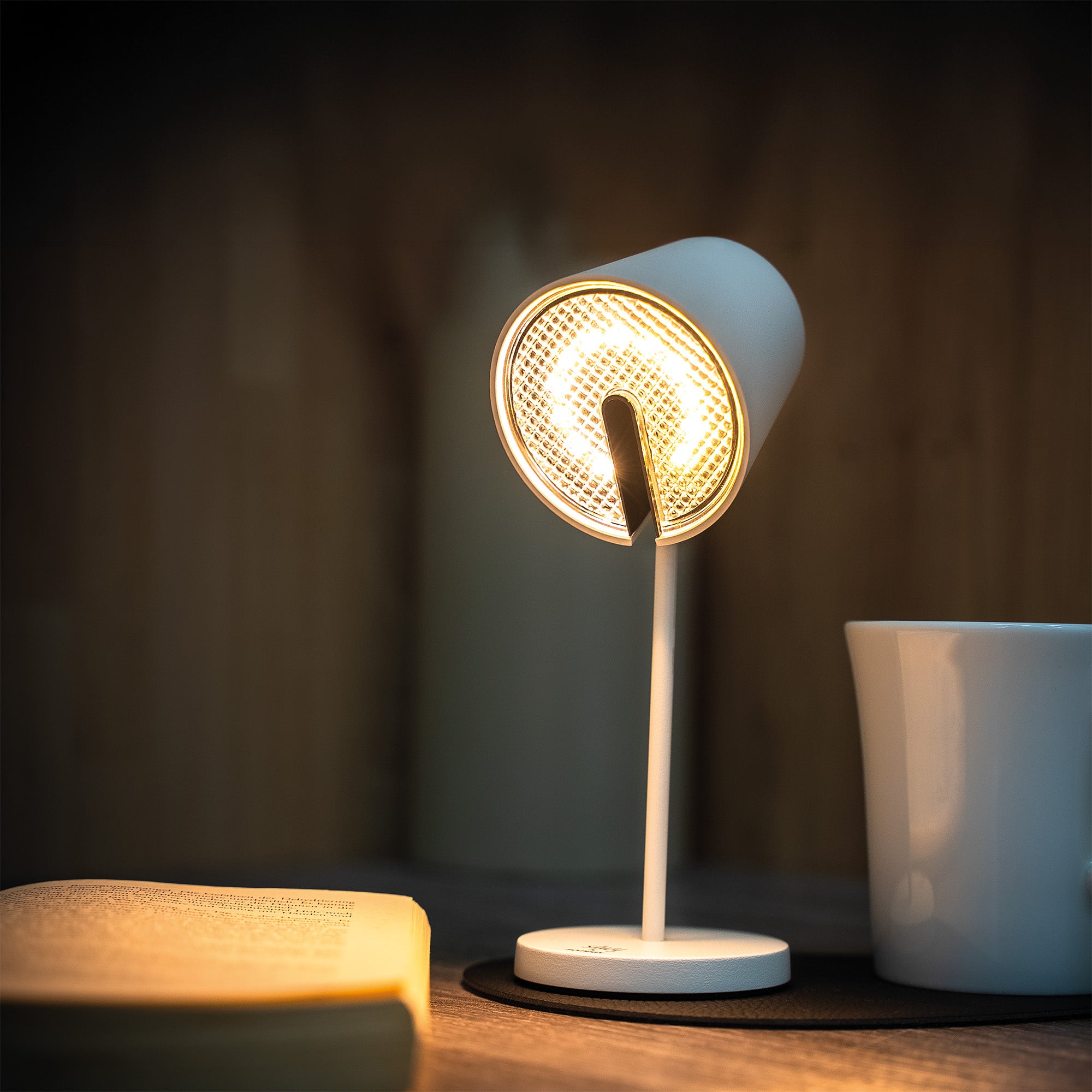 Infinitely dimmable luminaire with swivel head in white on placemat