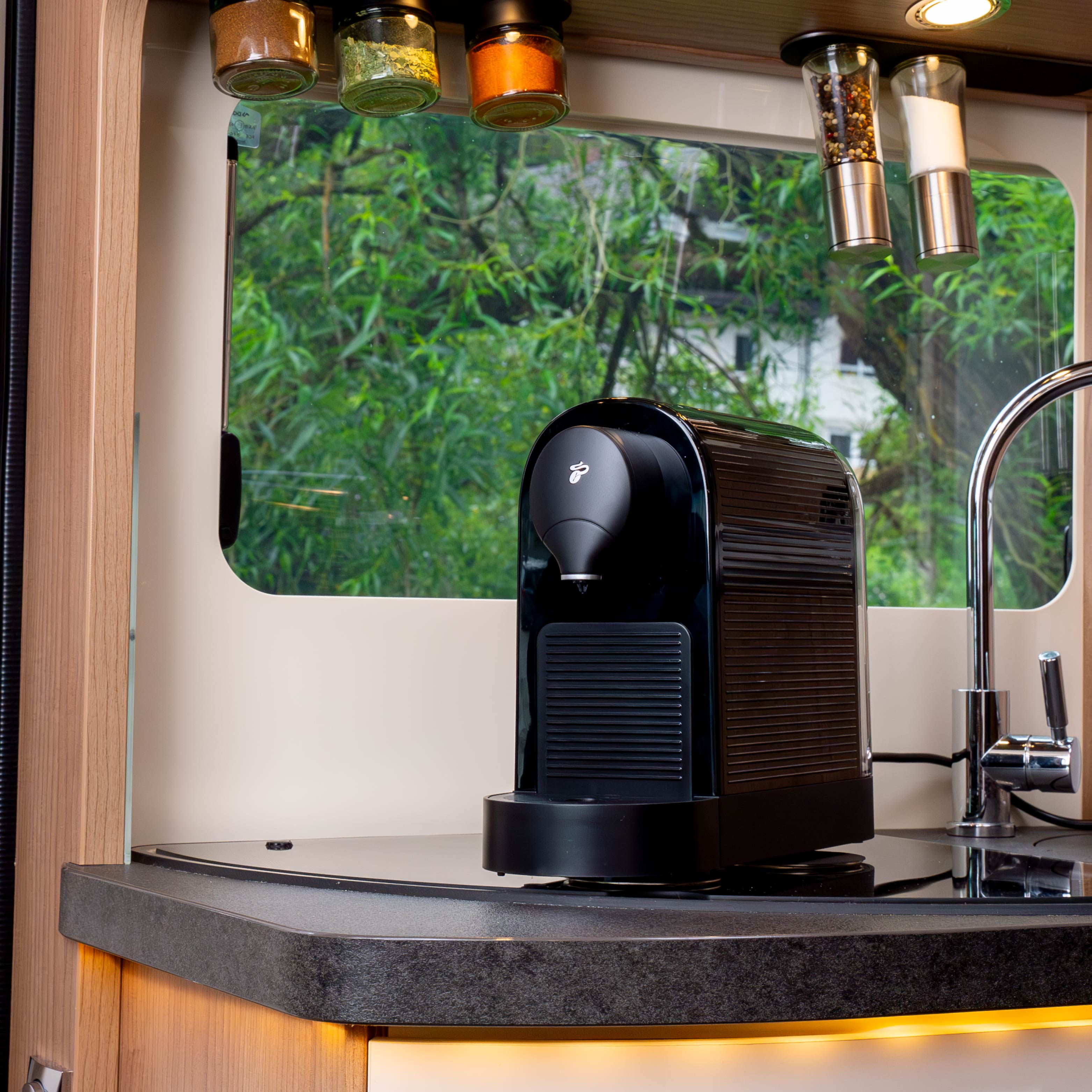 Power Bundle XXL - black coffee machine attached with power magnets to Metal nano gel pads in camper. Magnetic glasses for delicacies are attached upside down to black metal strips on the ceiling