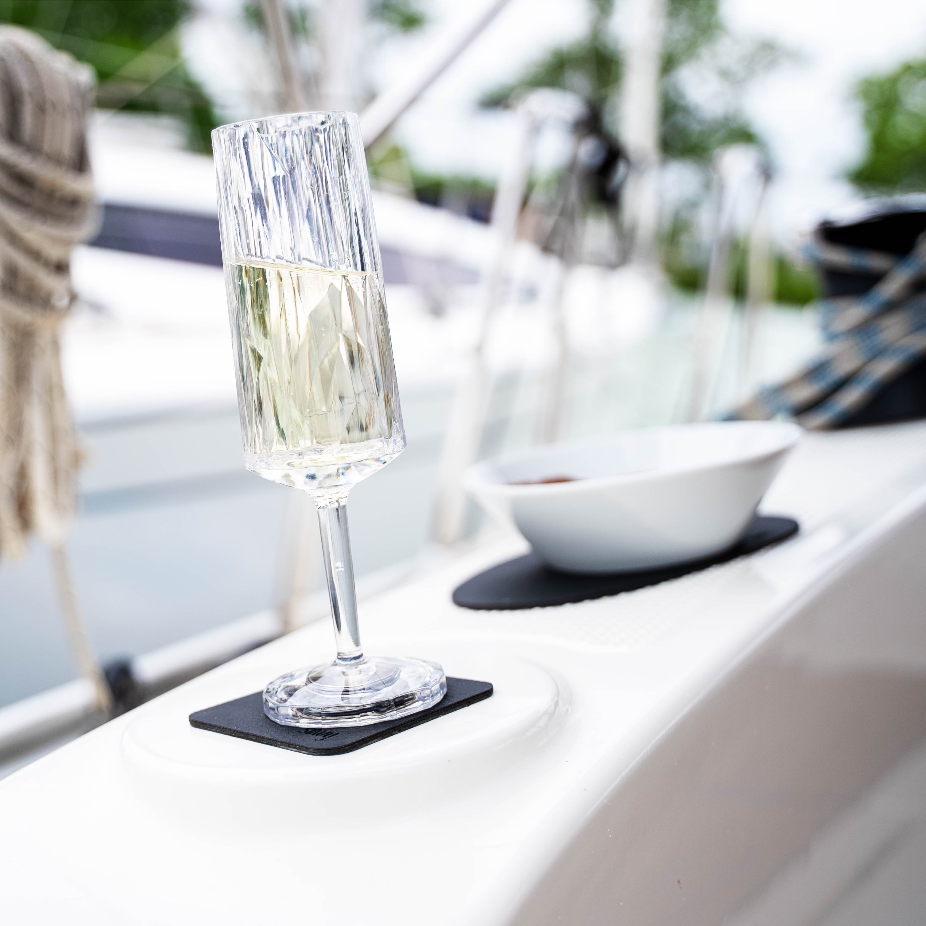 Magnetic plastic glass champagne on a pad on a boat in an inclined position