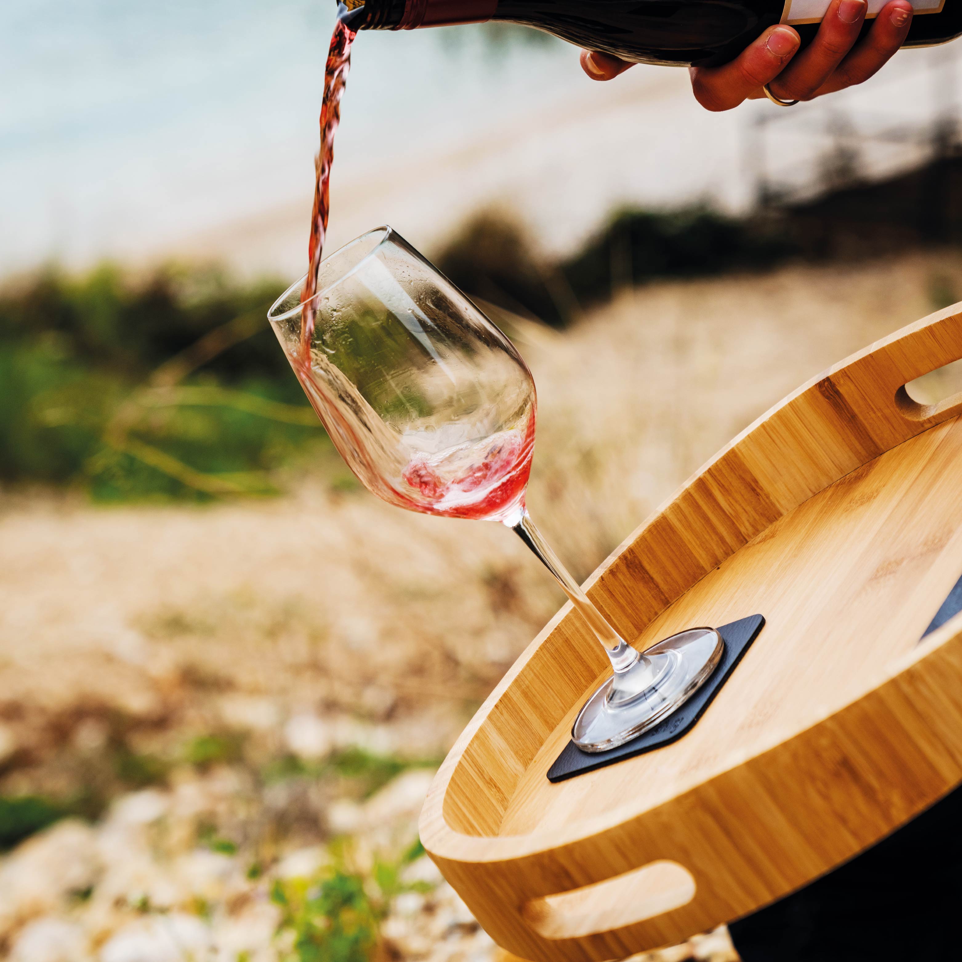 Magnetic crystal glass wine incl. square Metal-Nano-Gel-Pad on wooden tray while wine is being poured