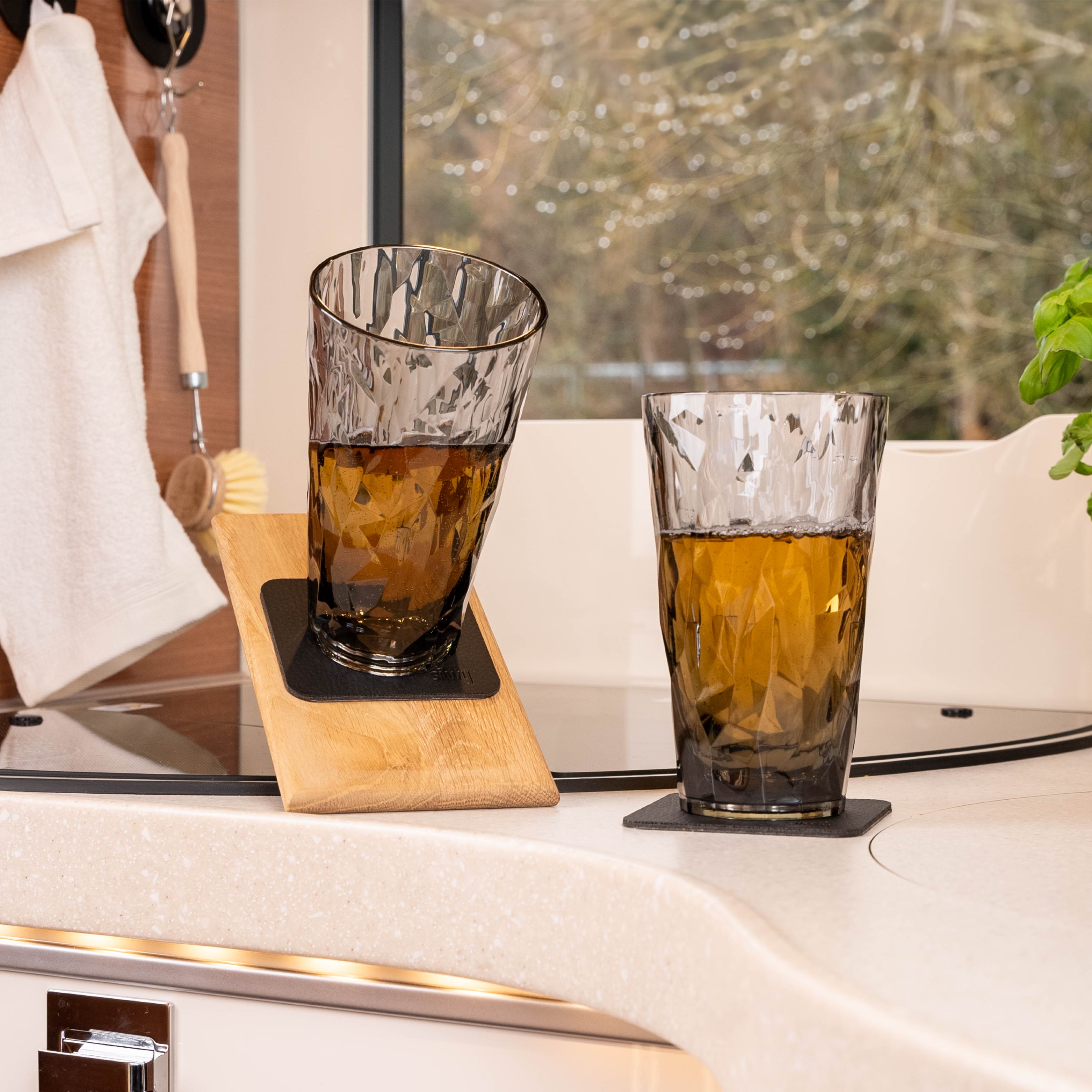 Vasos magnéticos de plástico Longdrink colocados sobre una almohadilla en posición inclinada en una caravana