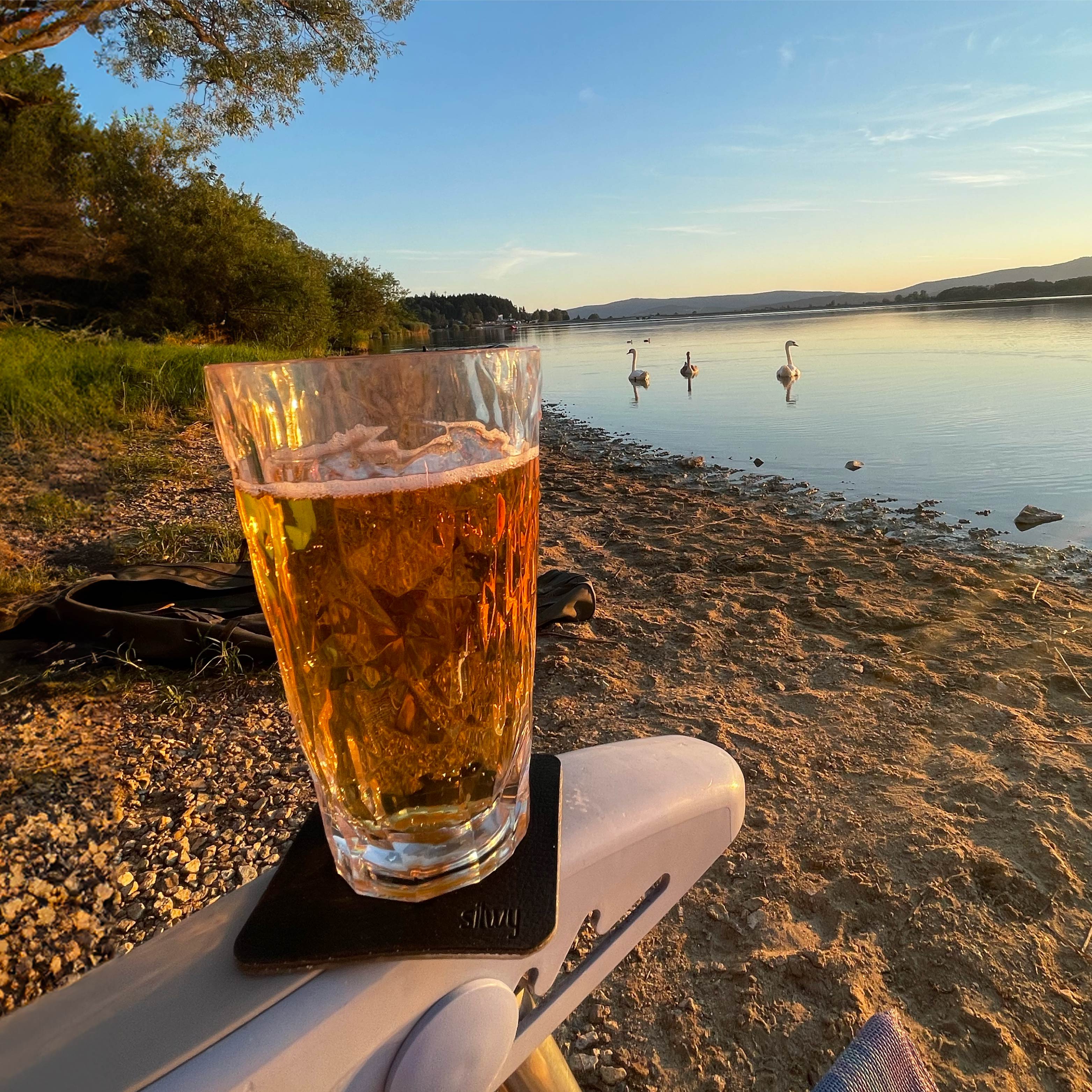 Verre à long drink en plastique magnétique sur un pad fixé sur l'accoudoir d'une chaise de camping