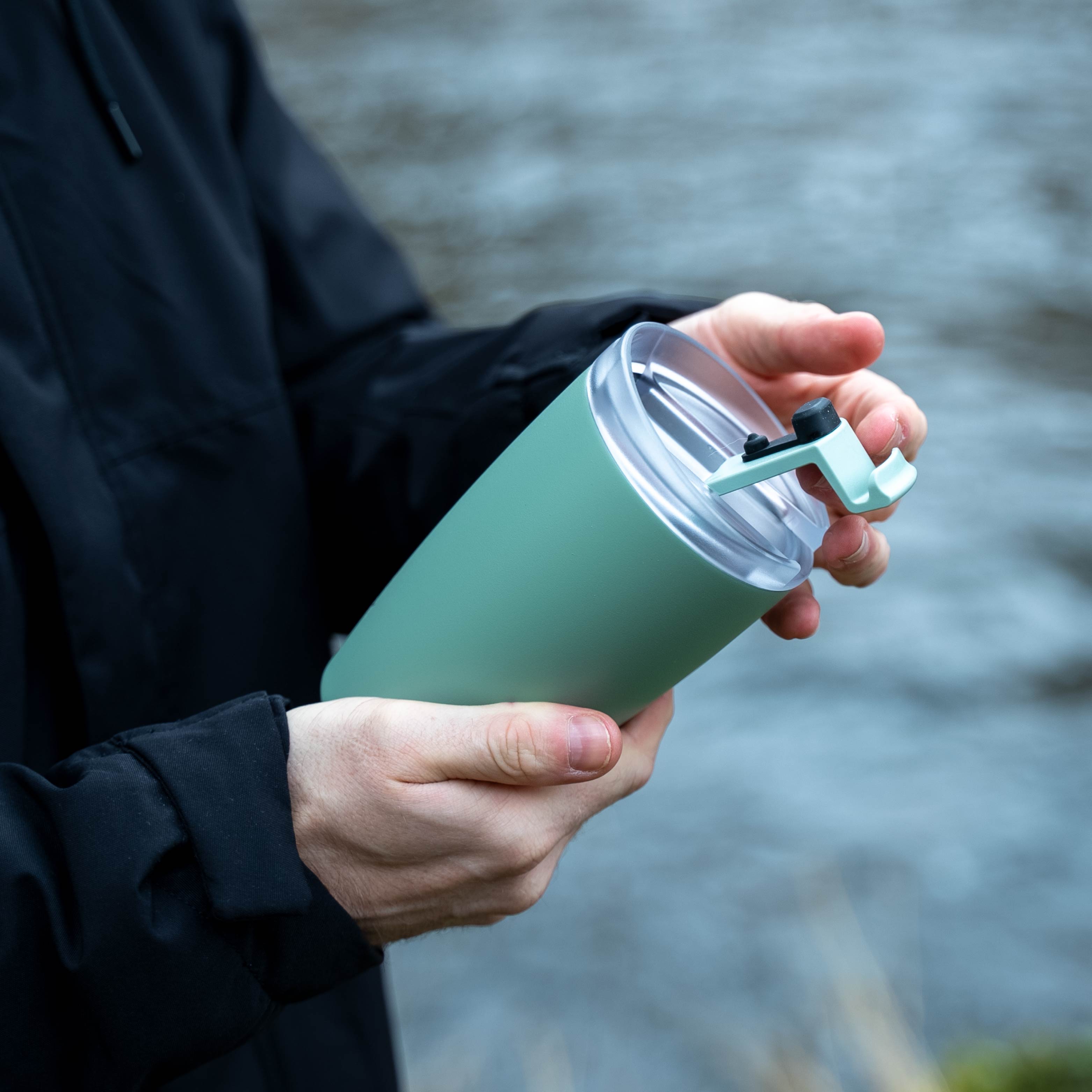Le silwy x FLSK Thermocup ouvert de couleur sage est ouvert et tenu à la main