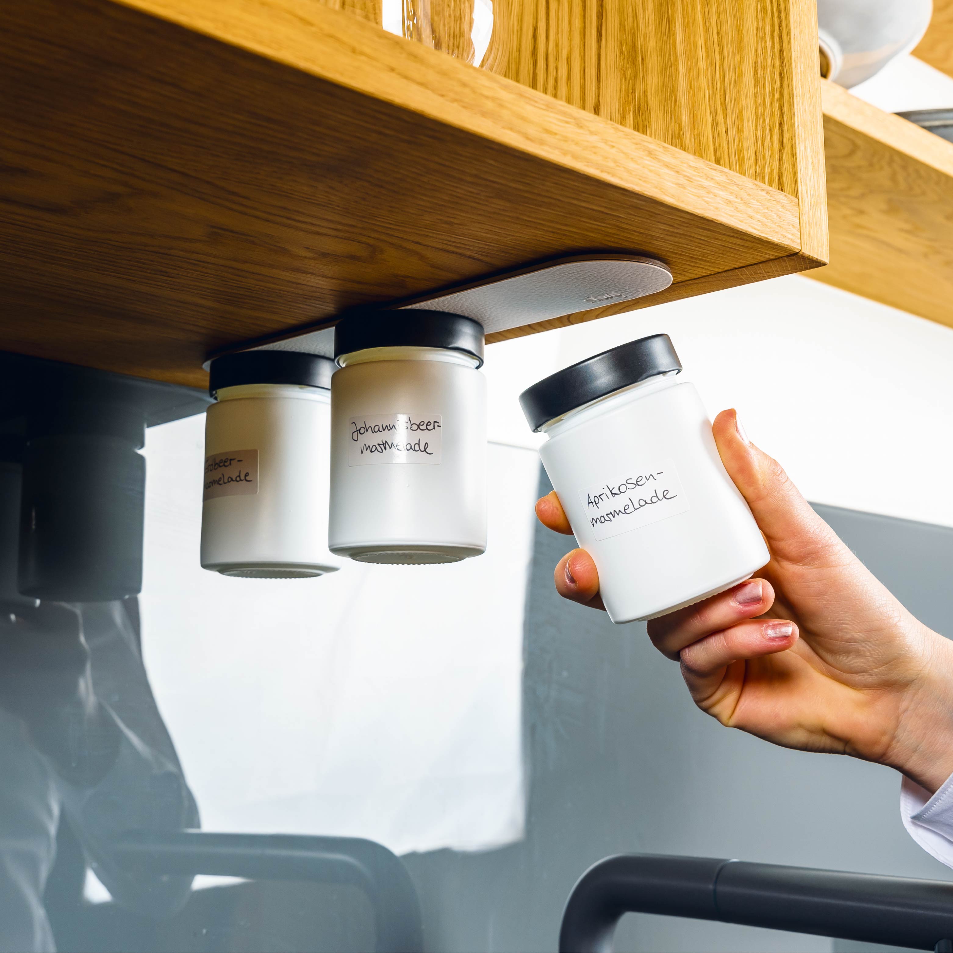 Pots à condiments magnétiques montés sur Barre Métallique dans l'environnement de la cuisine