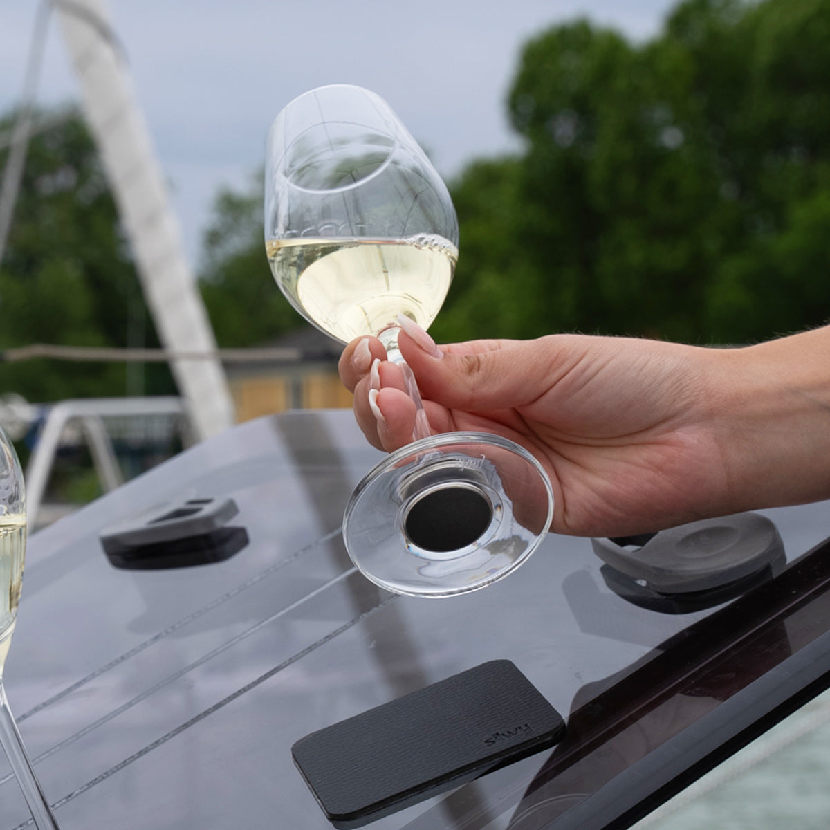 Bicchieri di cristallo magnetici riempiti di champagne tenuti in aria con un cuscinetto di nano-gel metallico