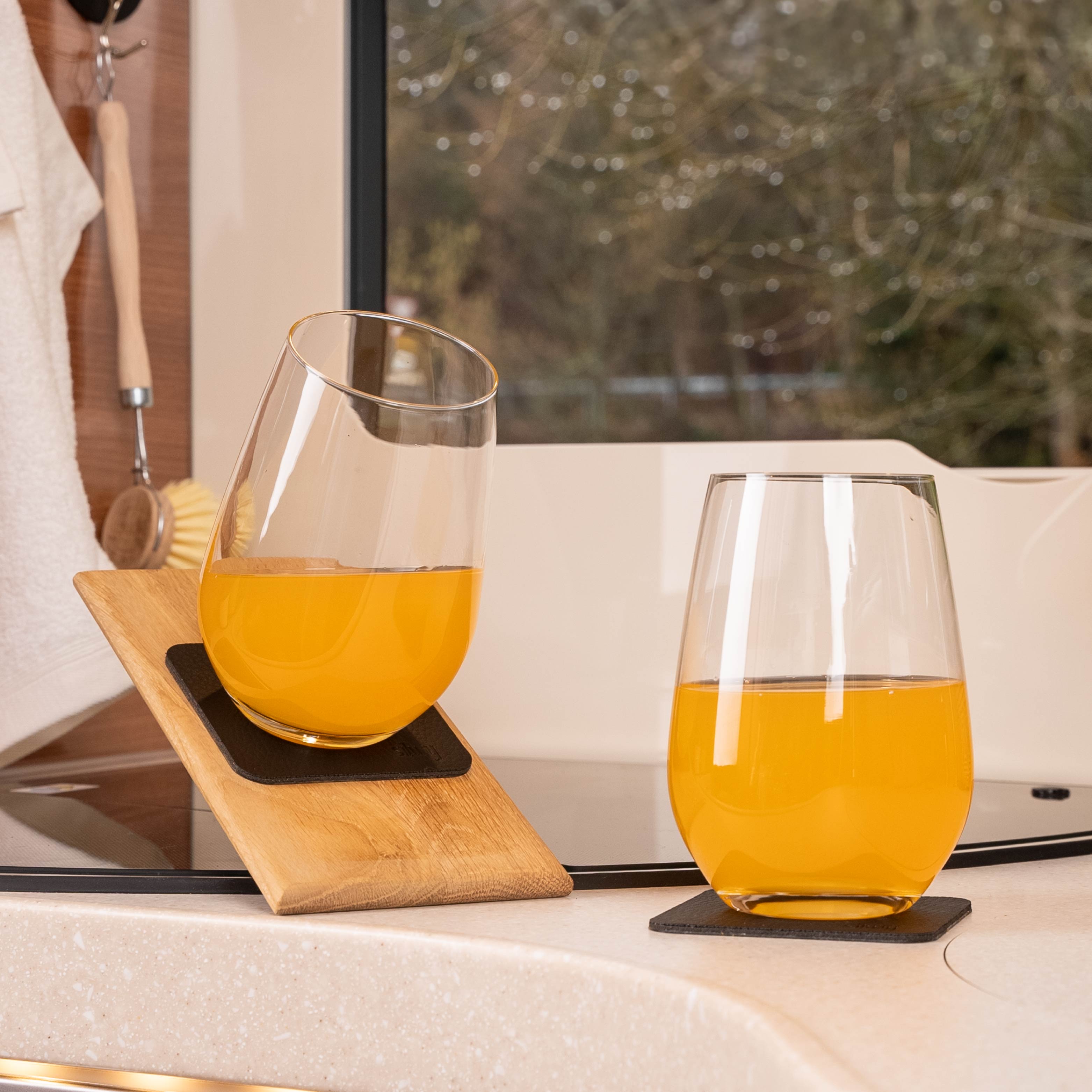 Bicchieri di cristallo magnetici per long drink su tappetini disposti obliquamente in camper