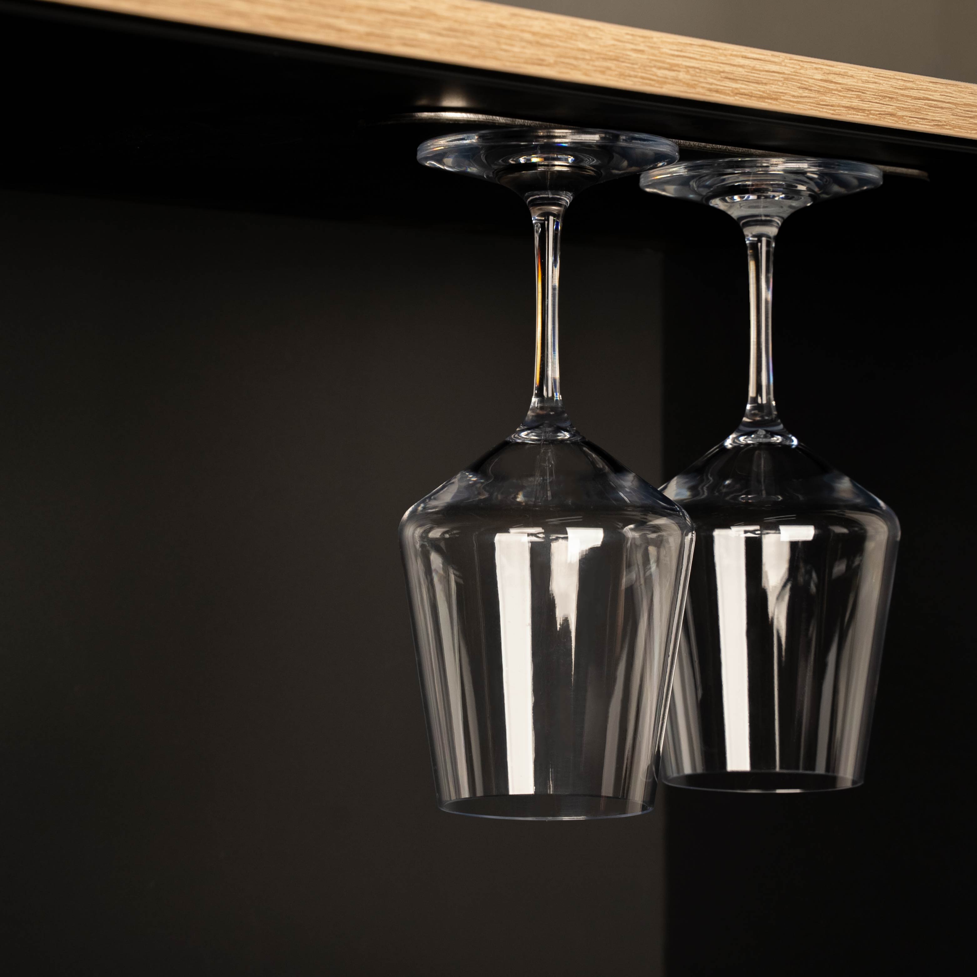 Bicchieri di vino in cristallo magnetico appesi a una striscia di metallo nero