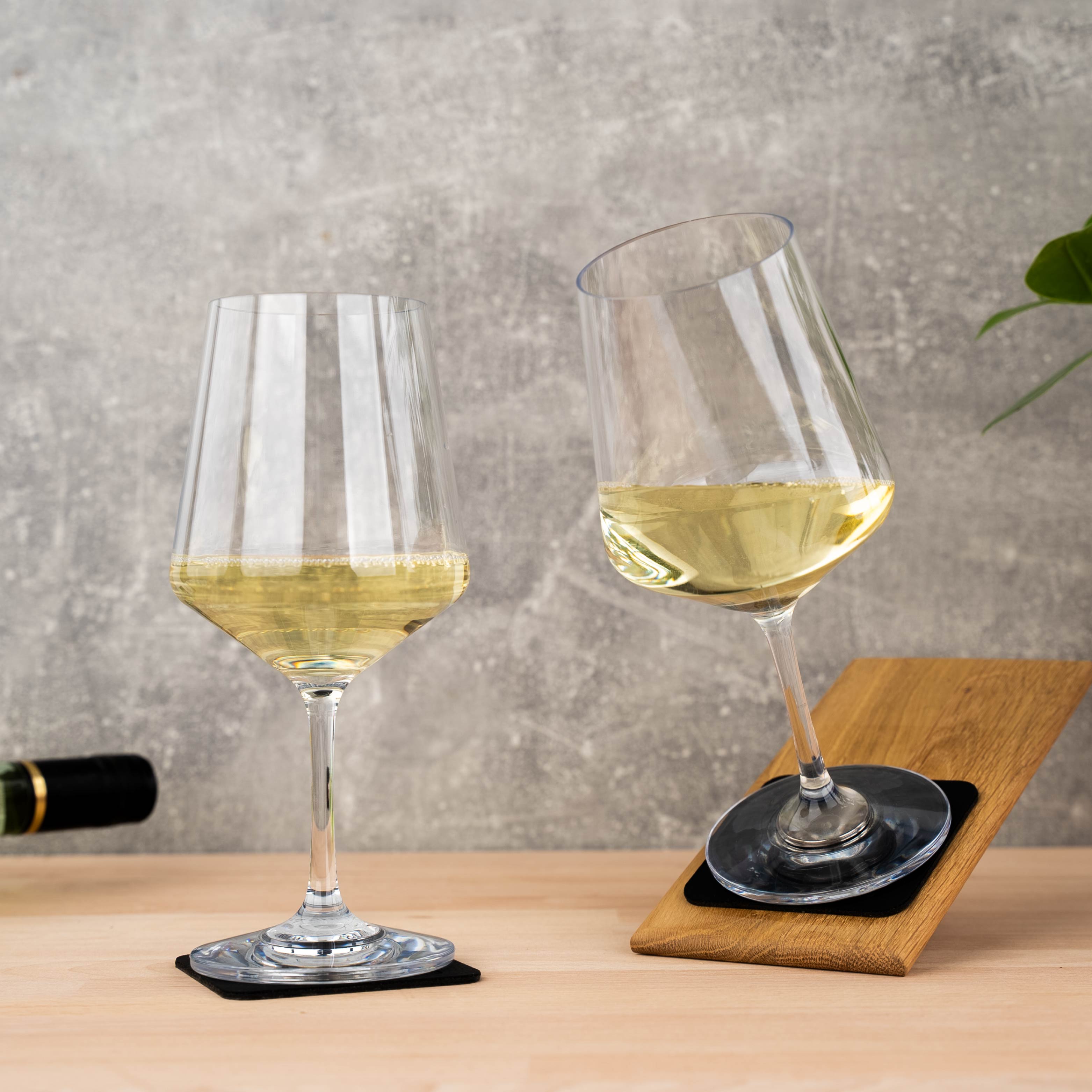 Bicchieri di cristallo magnetici di vino su pastiglie quadrate di metallo nano-gel nero