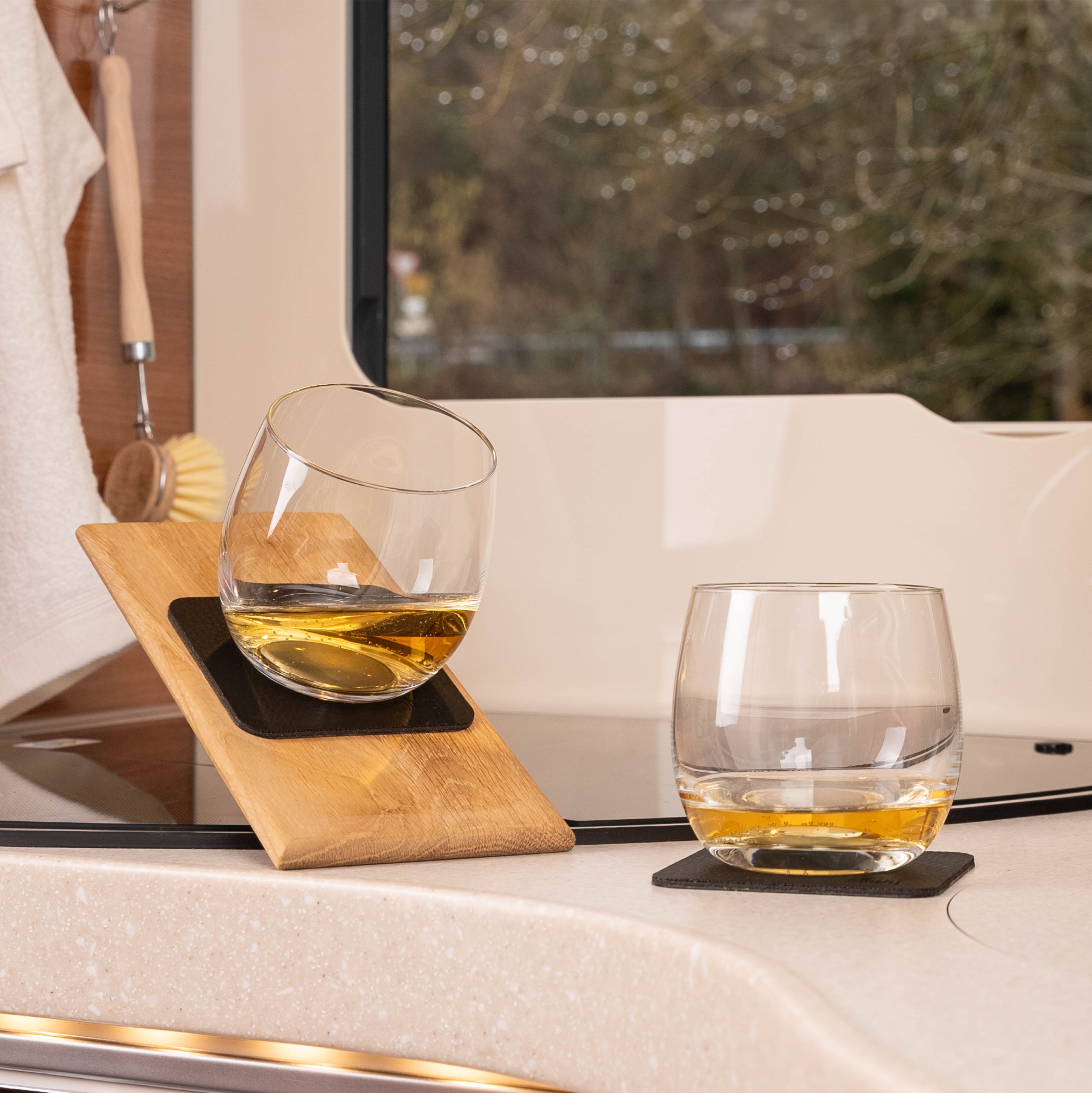 Bicchieri di cristallo magnetici da whisky su cuscinetti in posizione inclinata in un camper
