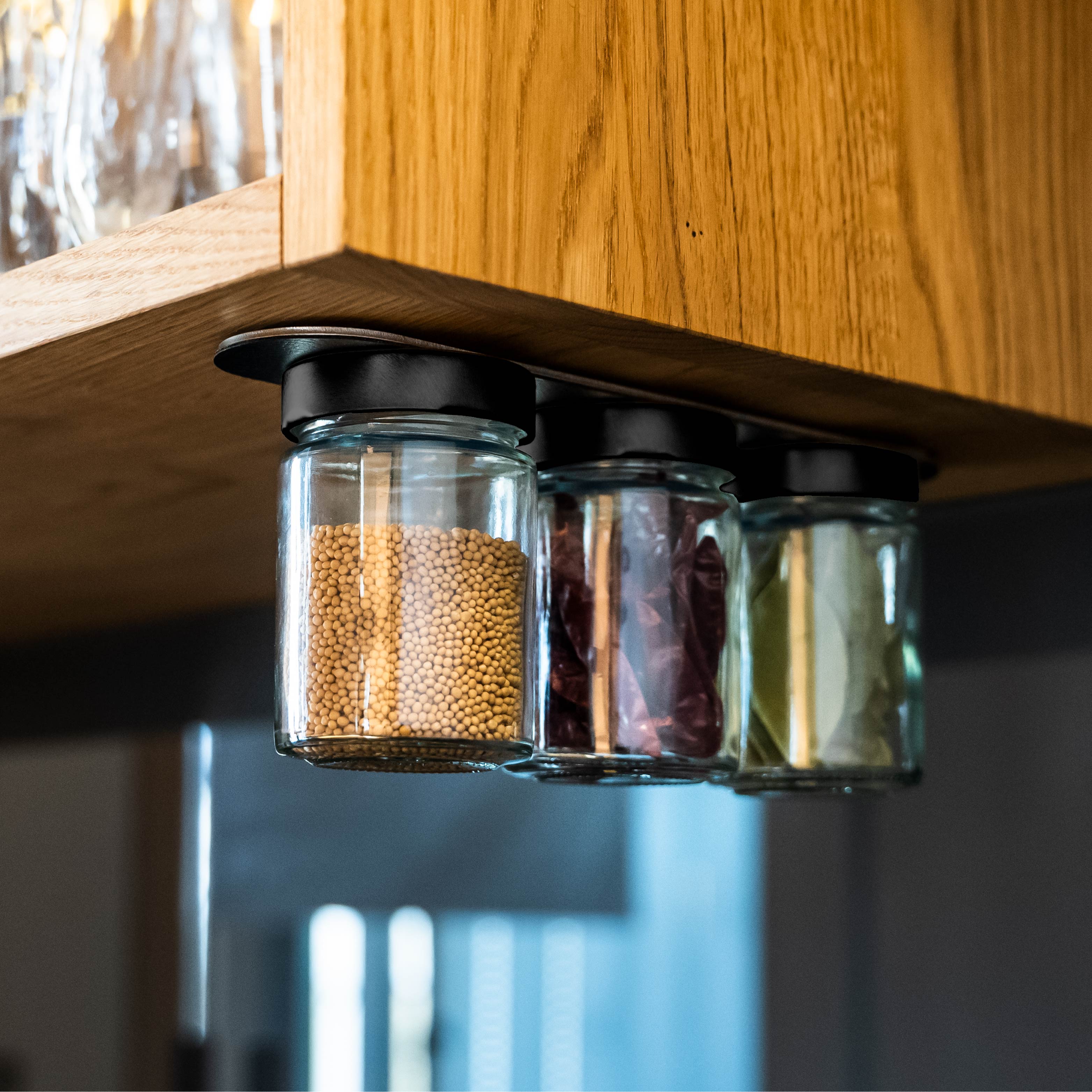 Vasetti magnetici per salumeria montati su una modanatura metallica in un ambiente di cucina