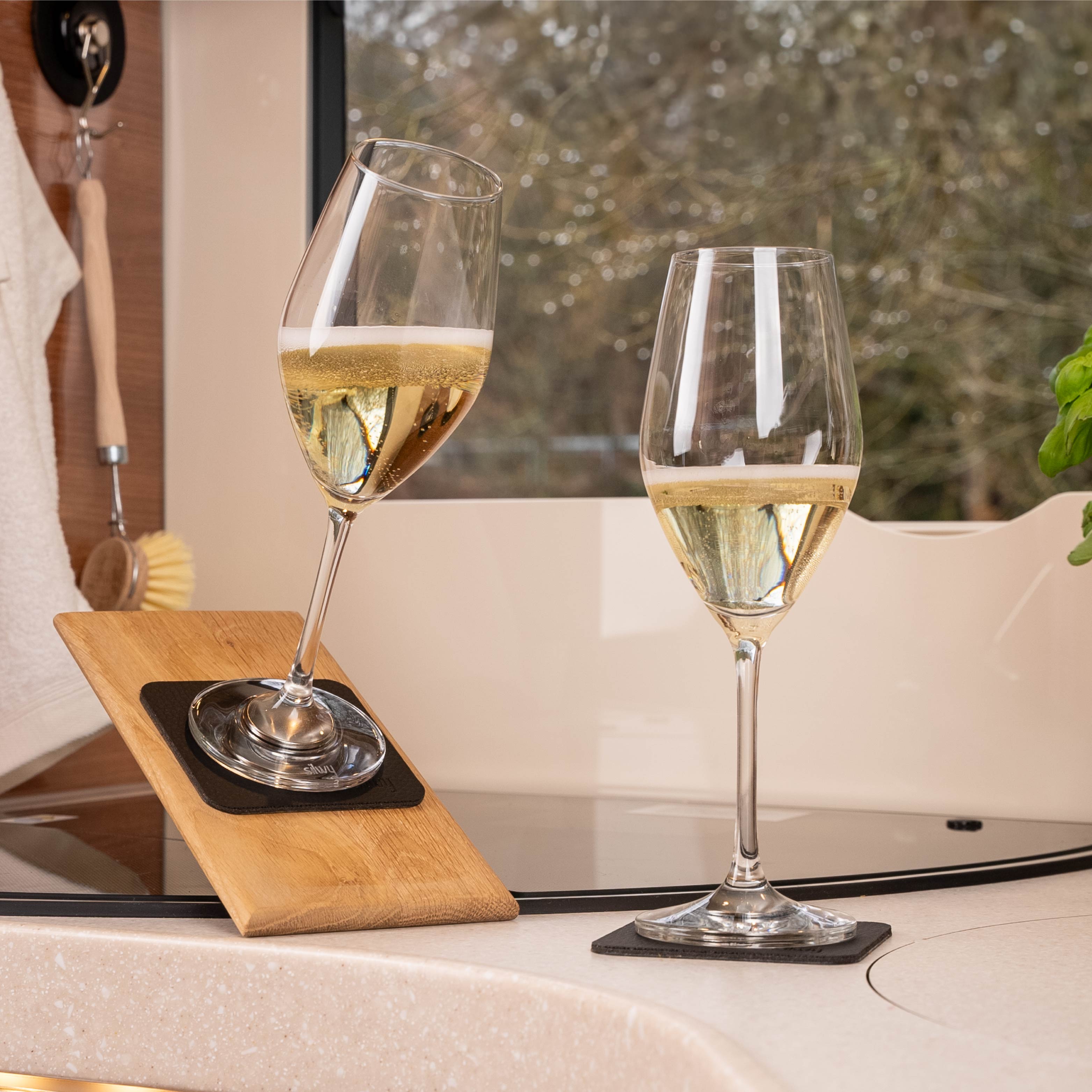 Calici di cristallo magnetici di champagne su cuscinetti in posizione inclinata in un camper