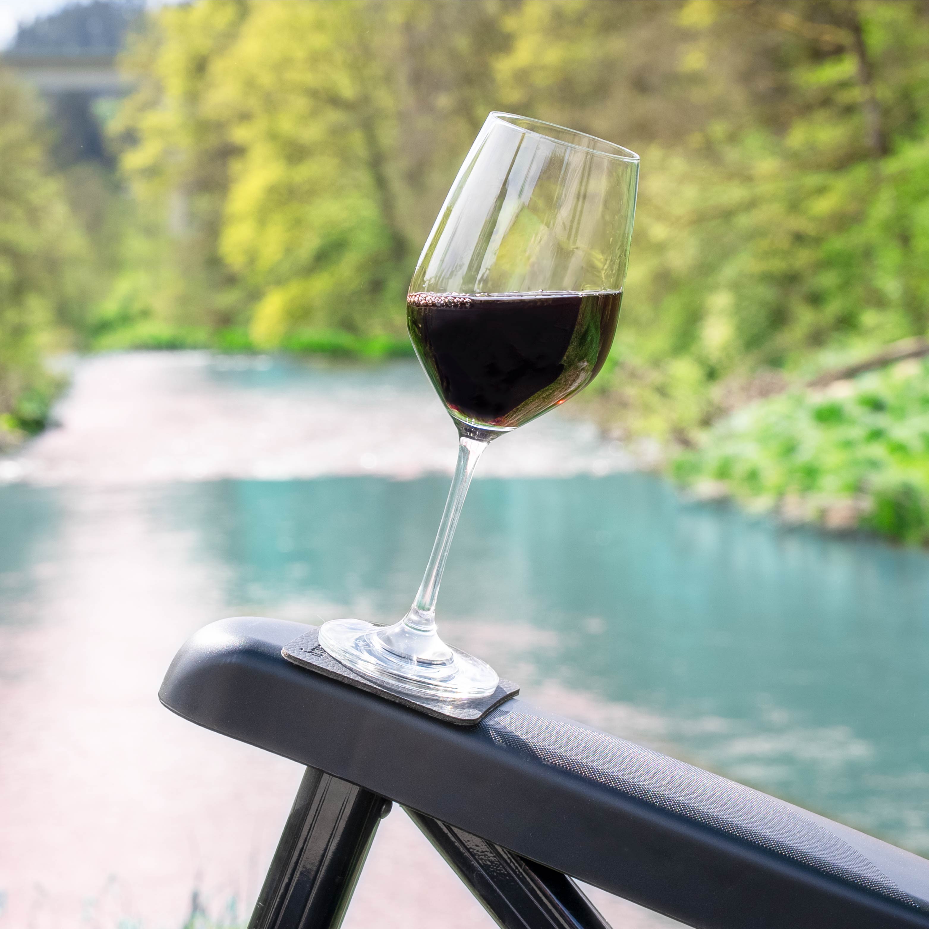 Bicchiere di vino in cristallo magnetico sul cuscinetto del bracciolo della sedia da campeggio