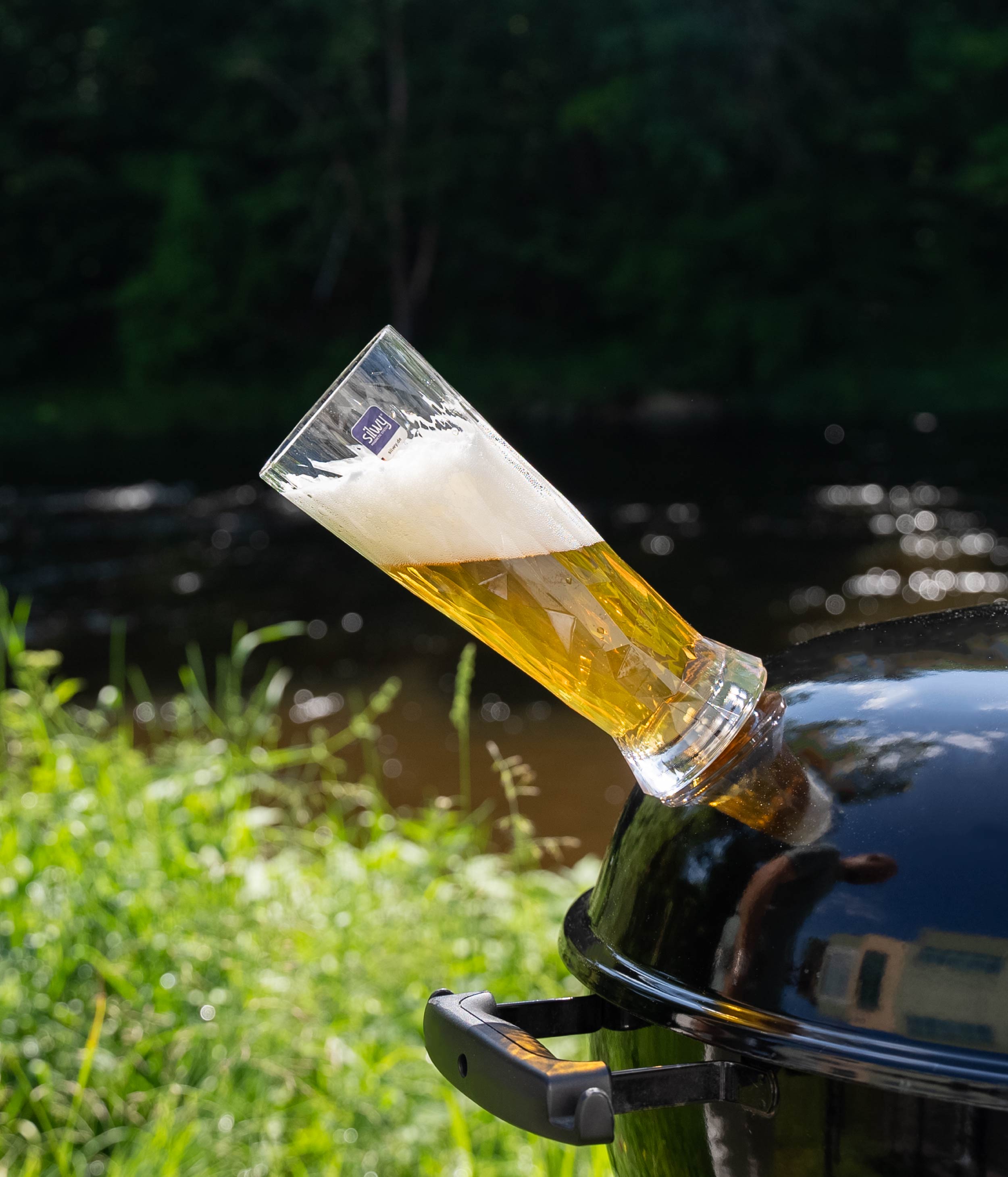Magnetic plastic beer glass on a kettle grill