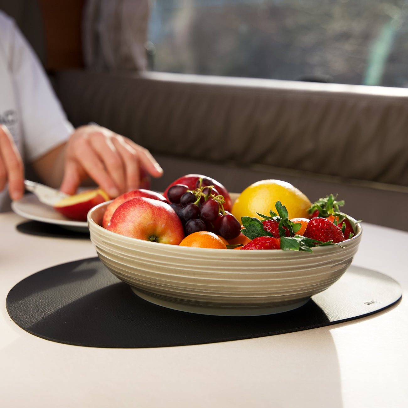 Magnetic porcelain food bowl filled with fruit on a metal mat 
