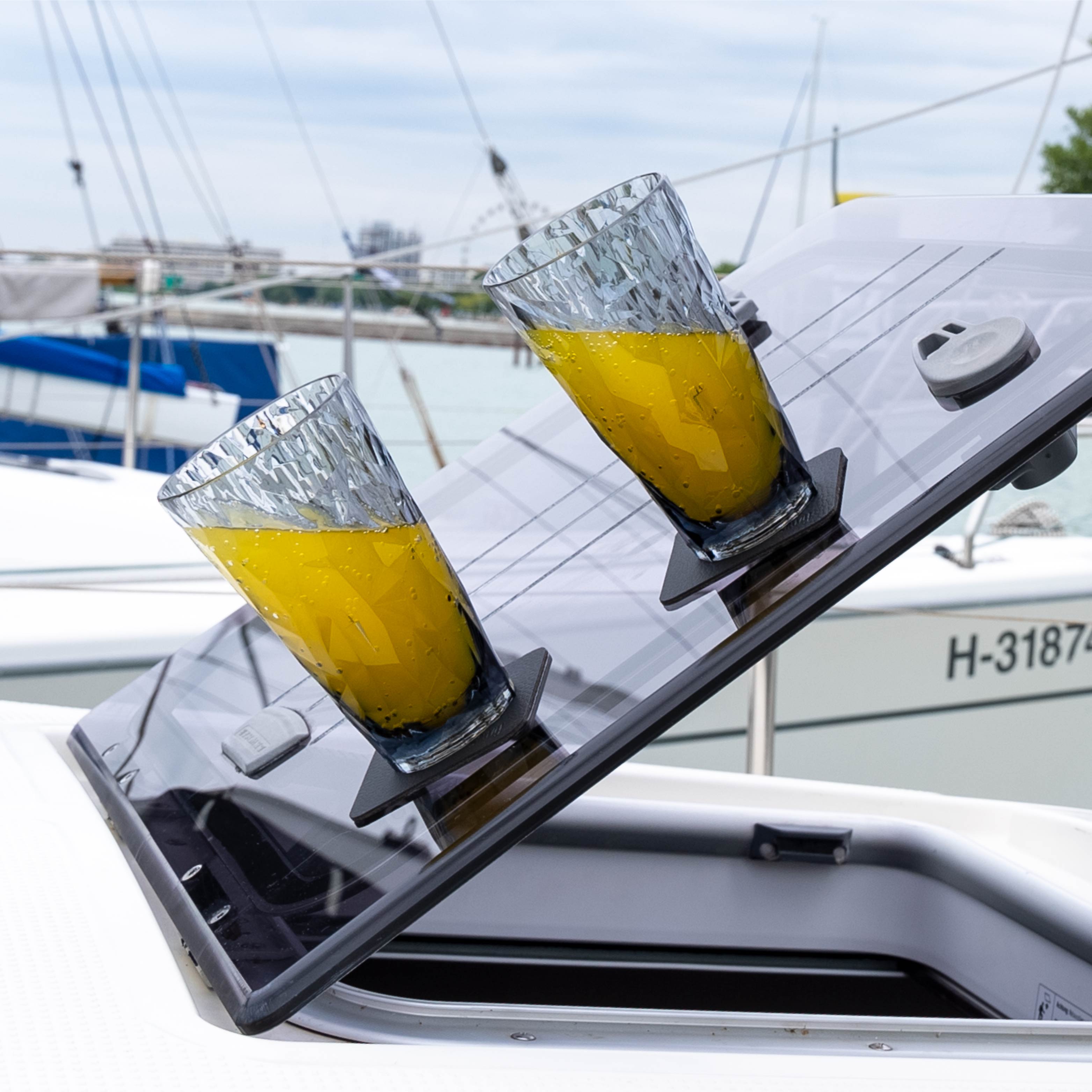 Two plastic long drink glasses with magnet in an inclined position on a boat