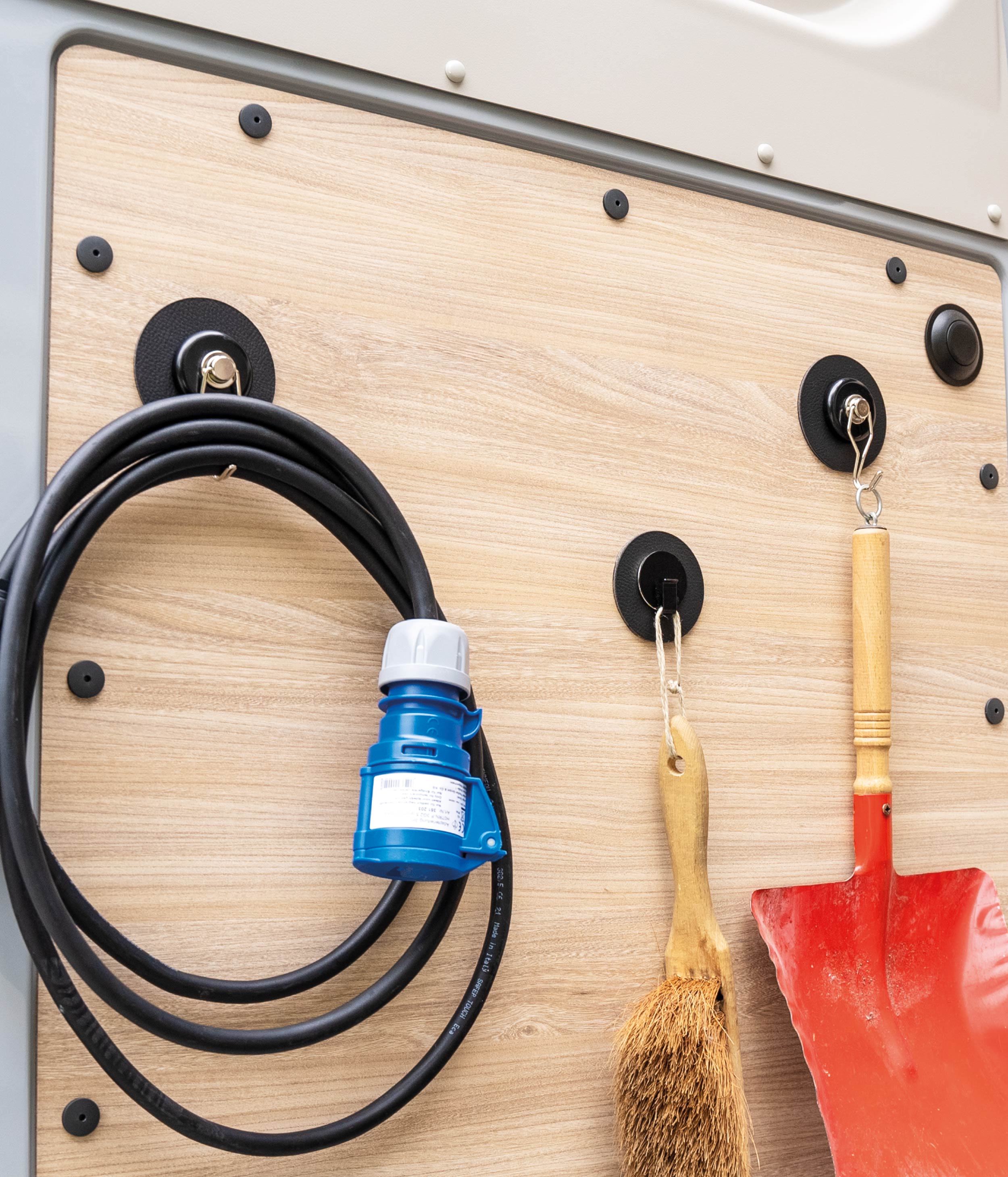 Various magnetic hooks attached to wooden wall with metal pads