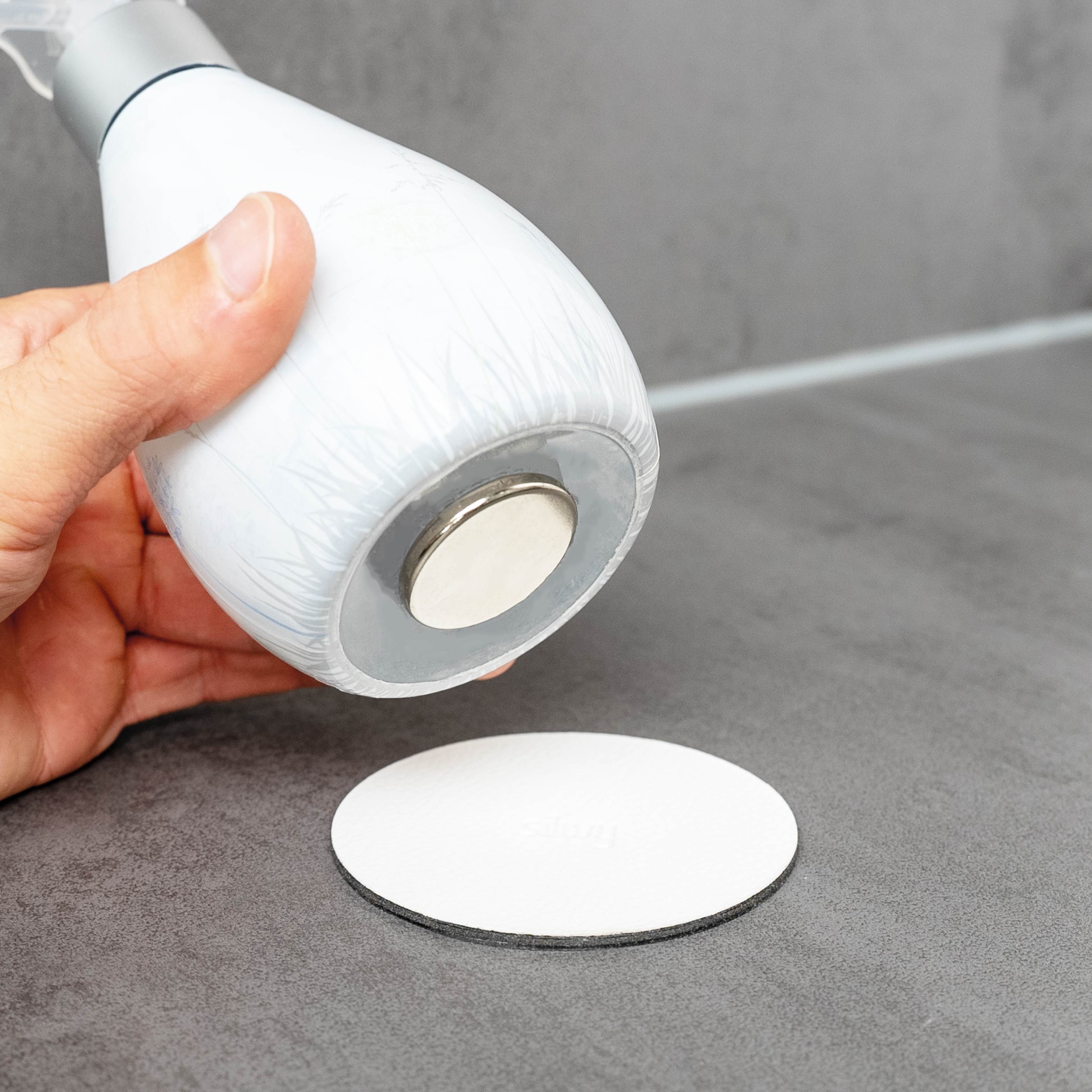Power magnet attached to soap dispenser with white, round Metal-Nano-Gel-Pad