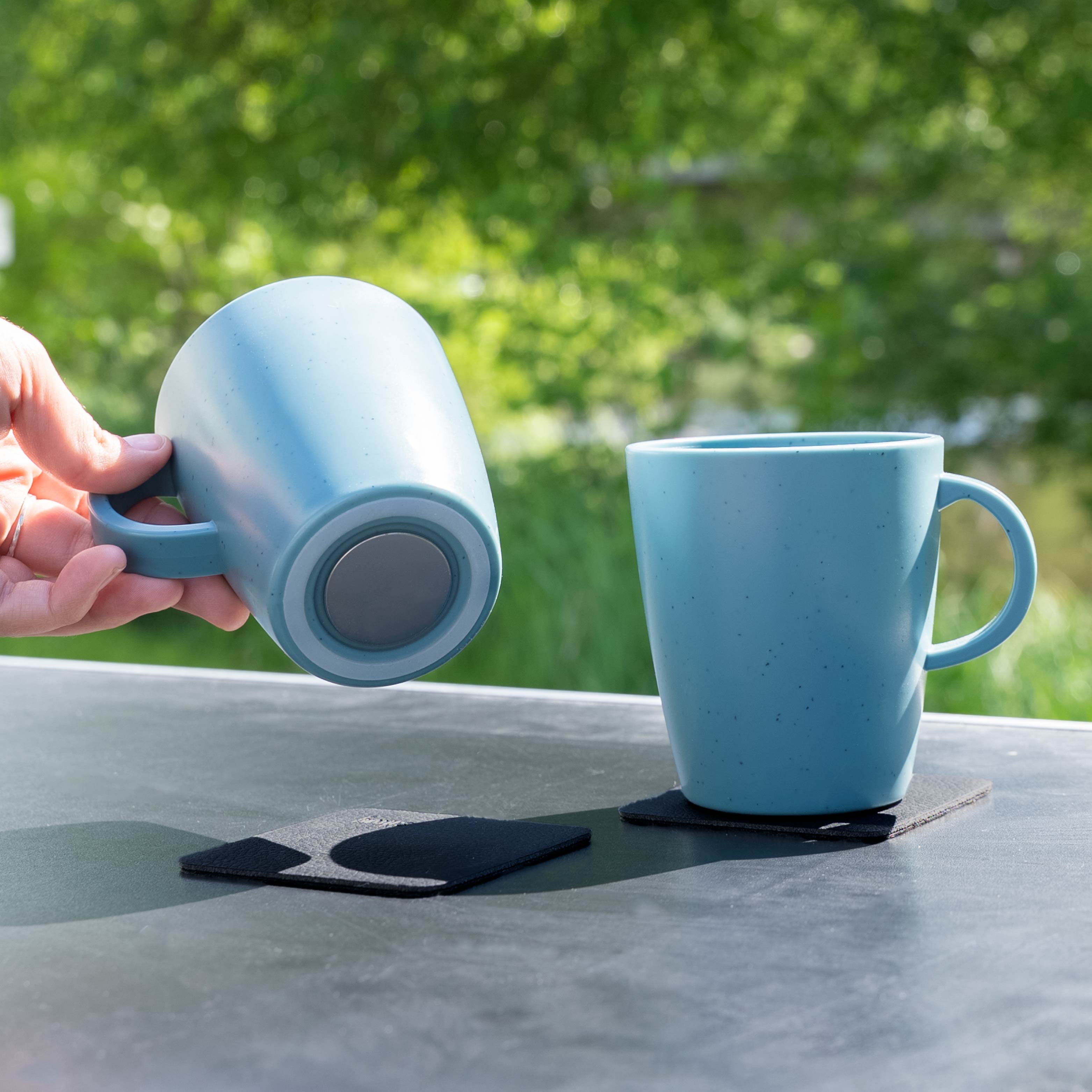 Magnetic plastic cups blue on camping table from below
