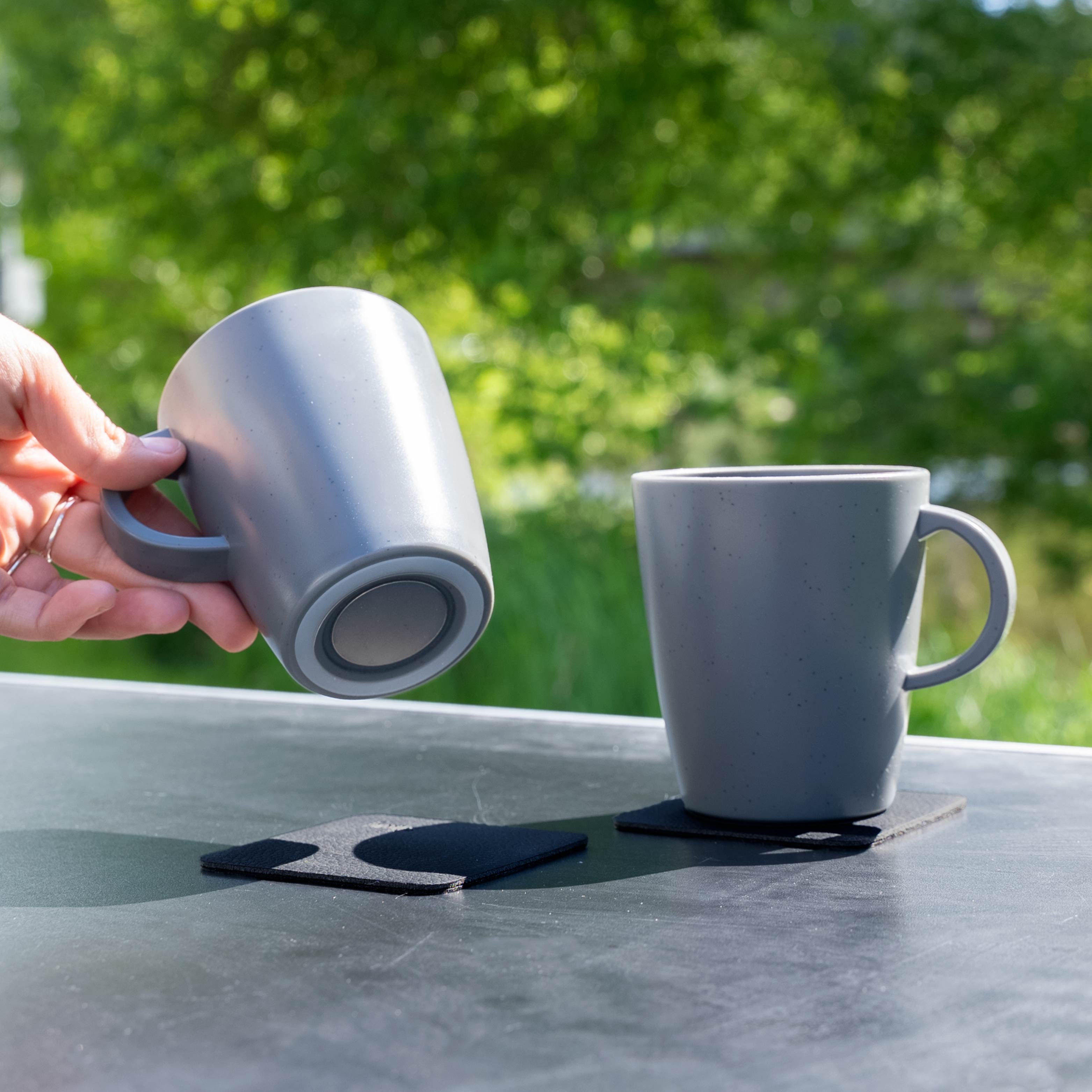 Magnetic plastic cups grey on camping table from below