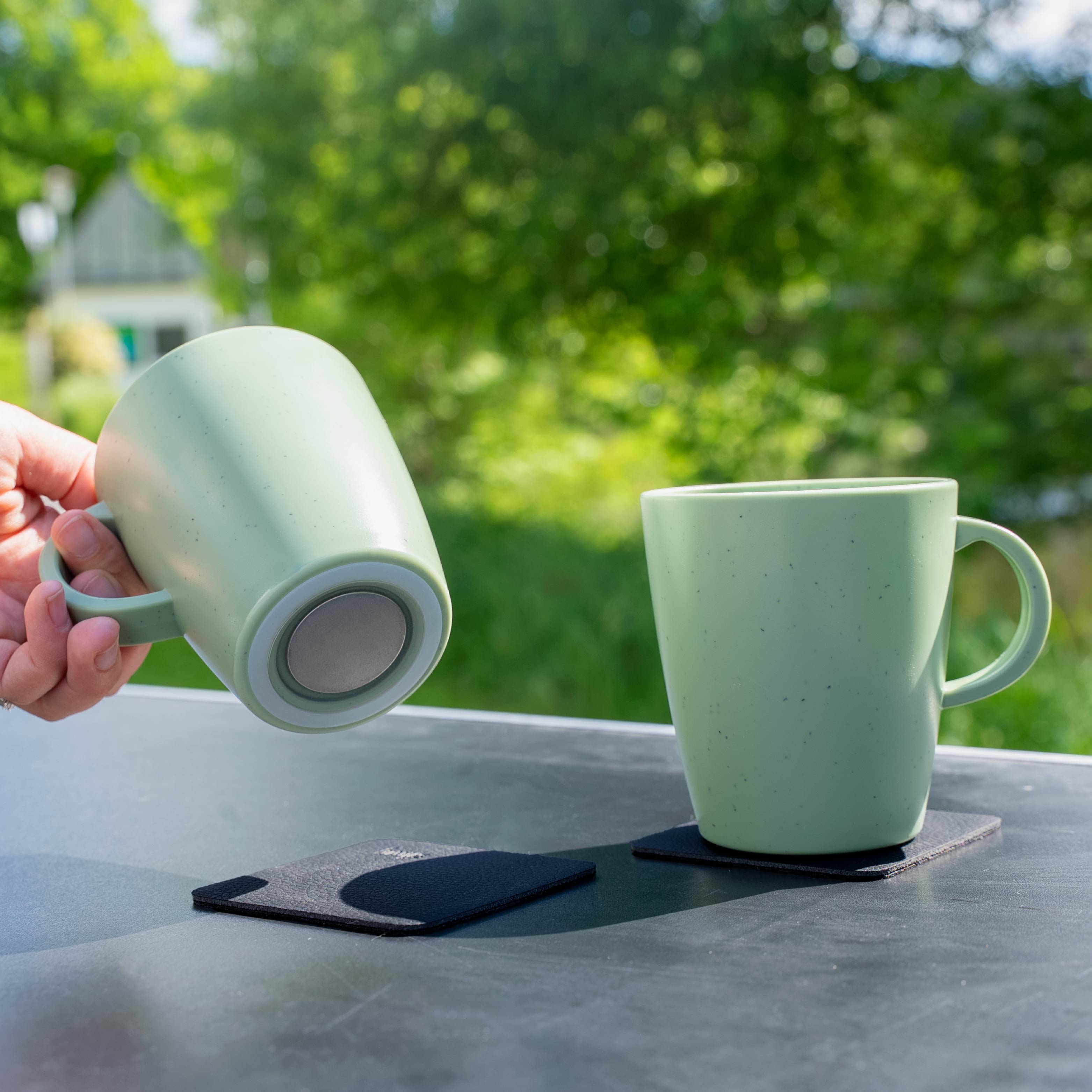 Magnetic plastic cups green on camping table from below