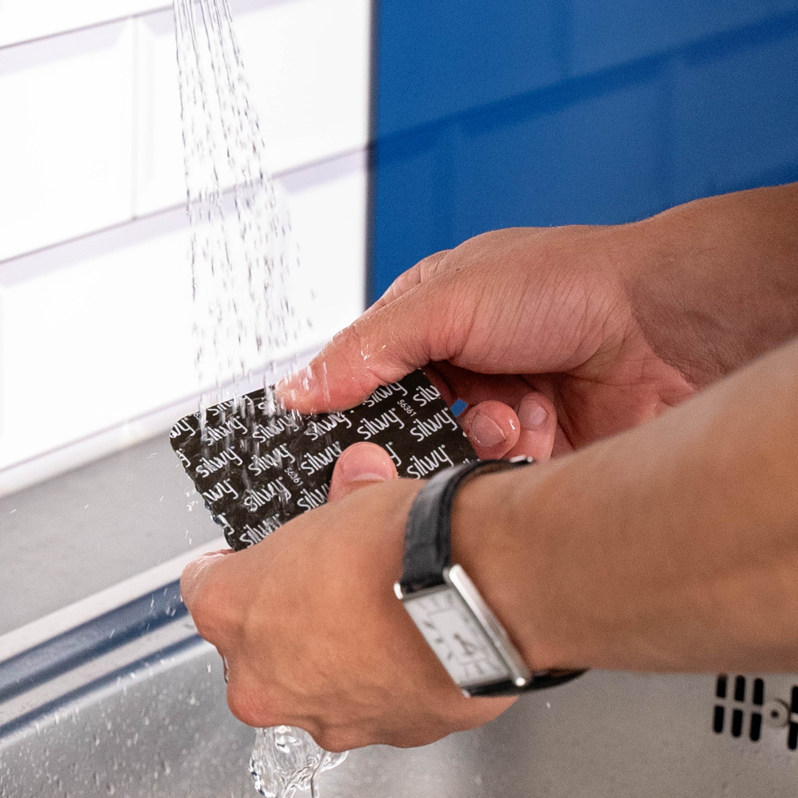 Washing off the square Metal nano gel pads under clear water 