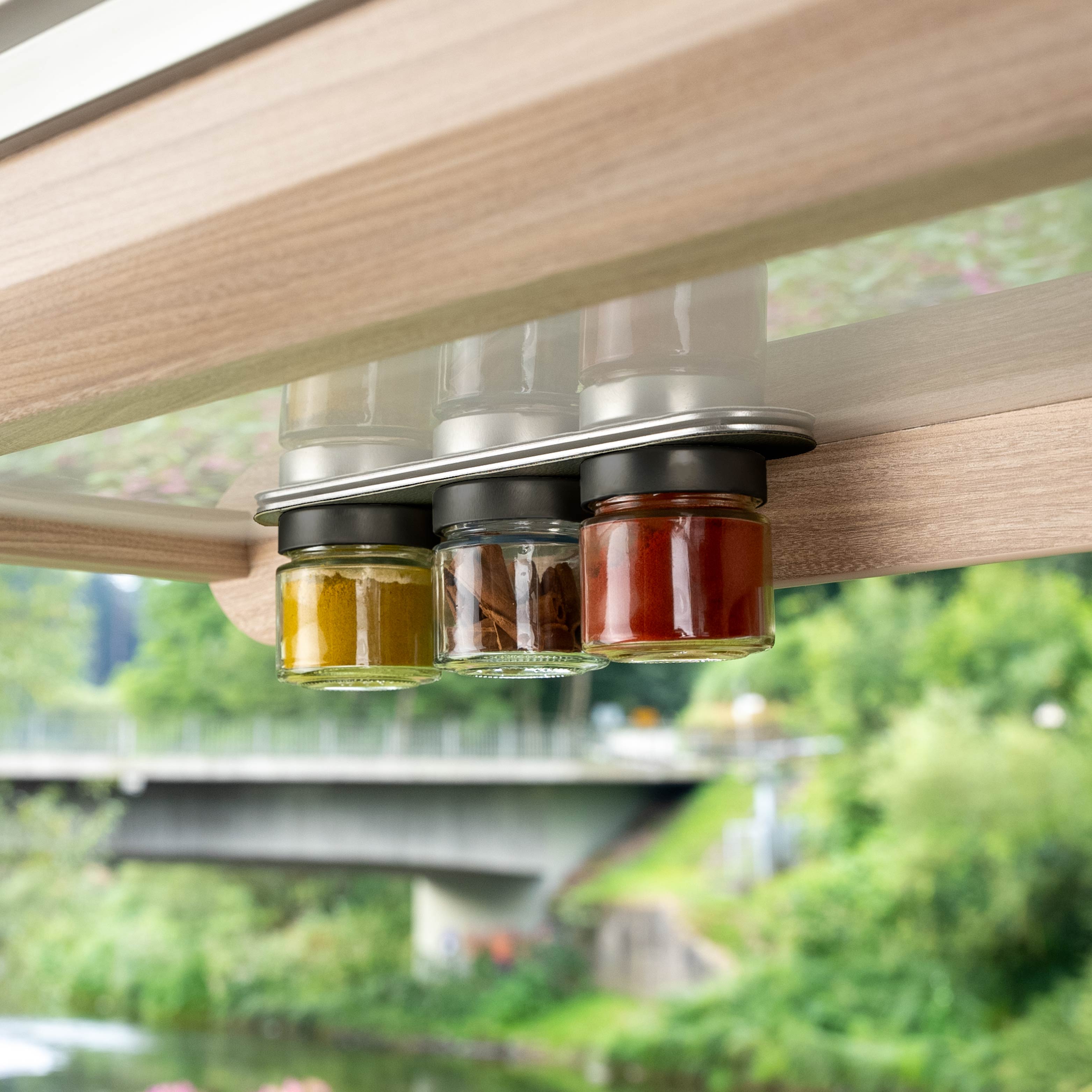 Magnetic delicatessen jars hanging on a rail in the camper 