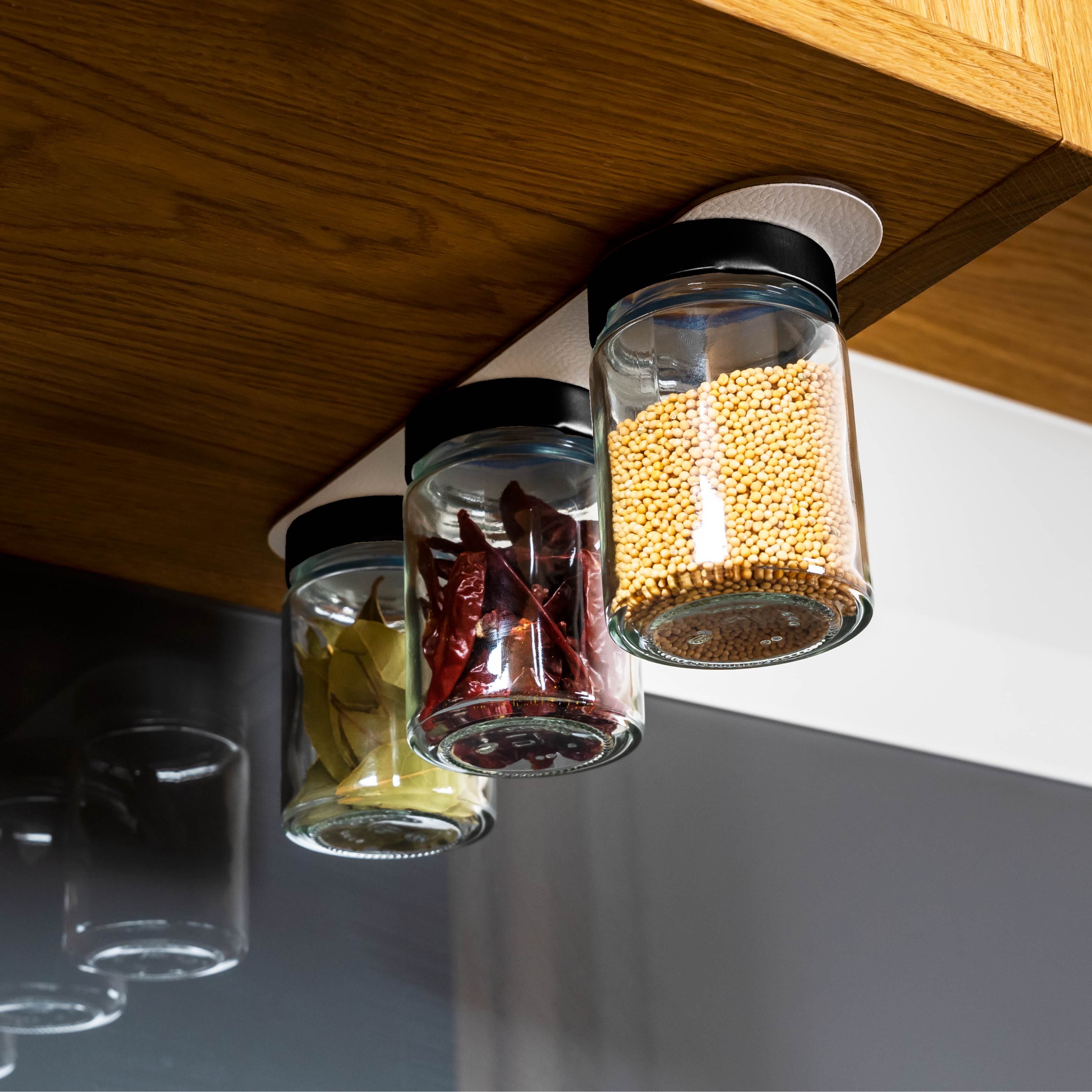Magnetic deli jars mounted on metal strip in kitchen environment 