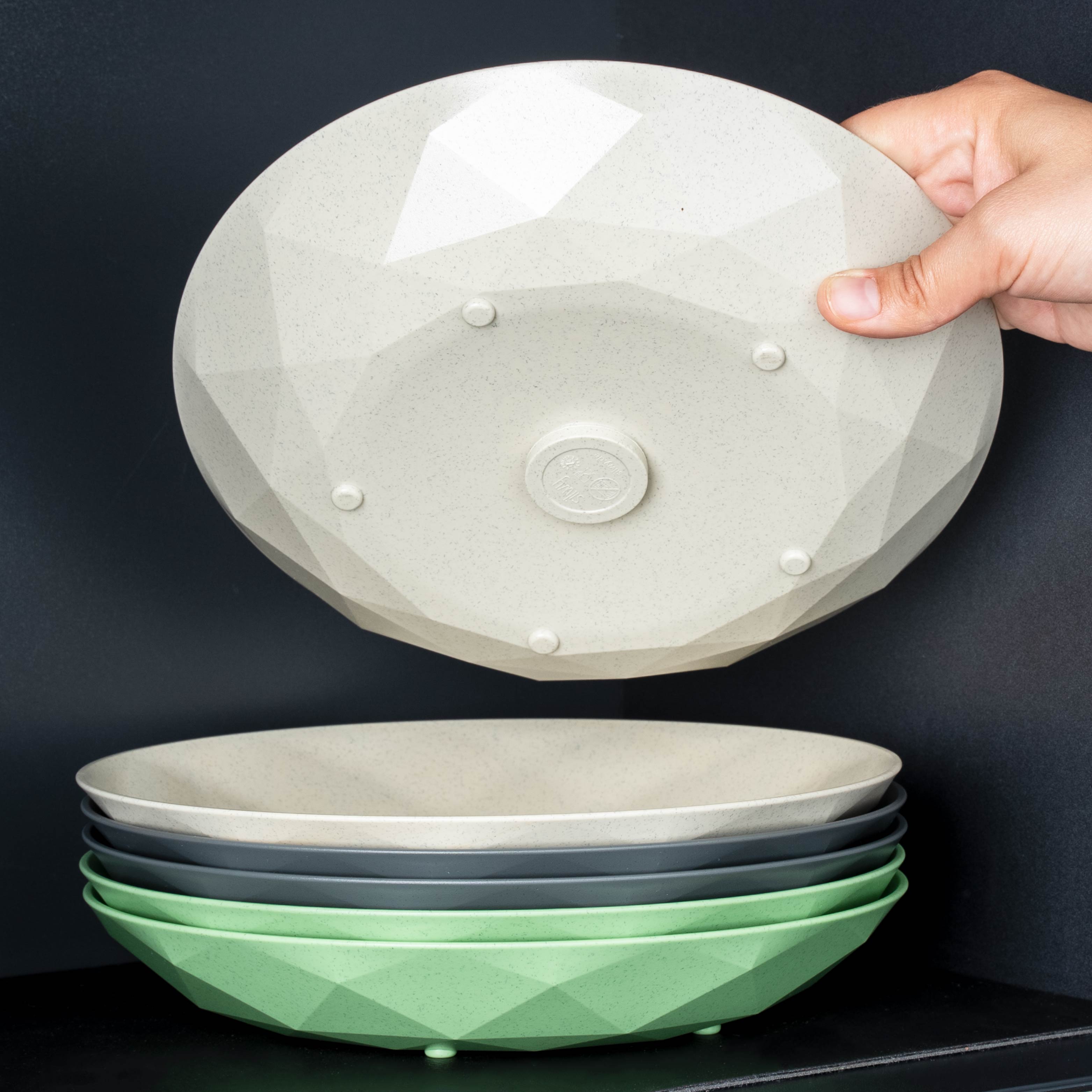 Assiettes en plastique magnétiques en beige, grey et green empilées les unes sur les autres 
