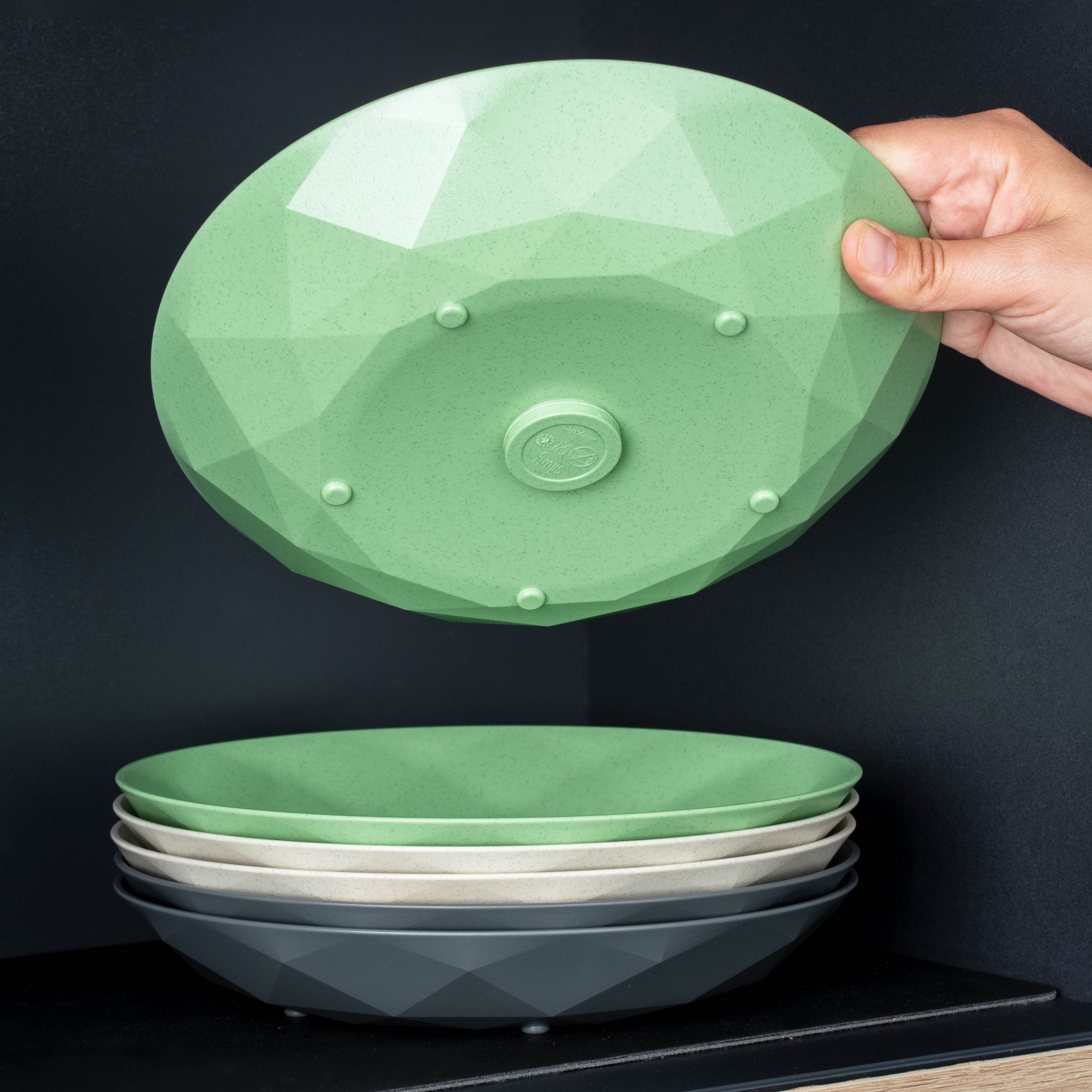Assiettes en plastique magnétiques classic in green, beige et grey empilées les unes sur les autres 