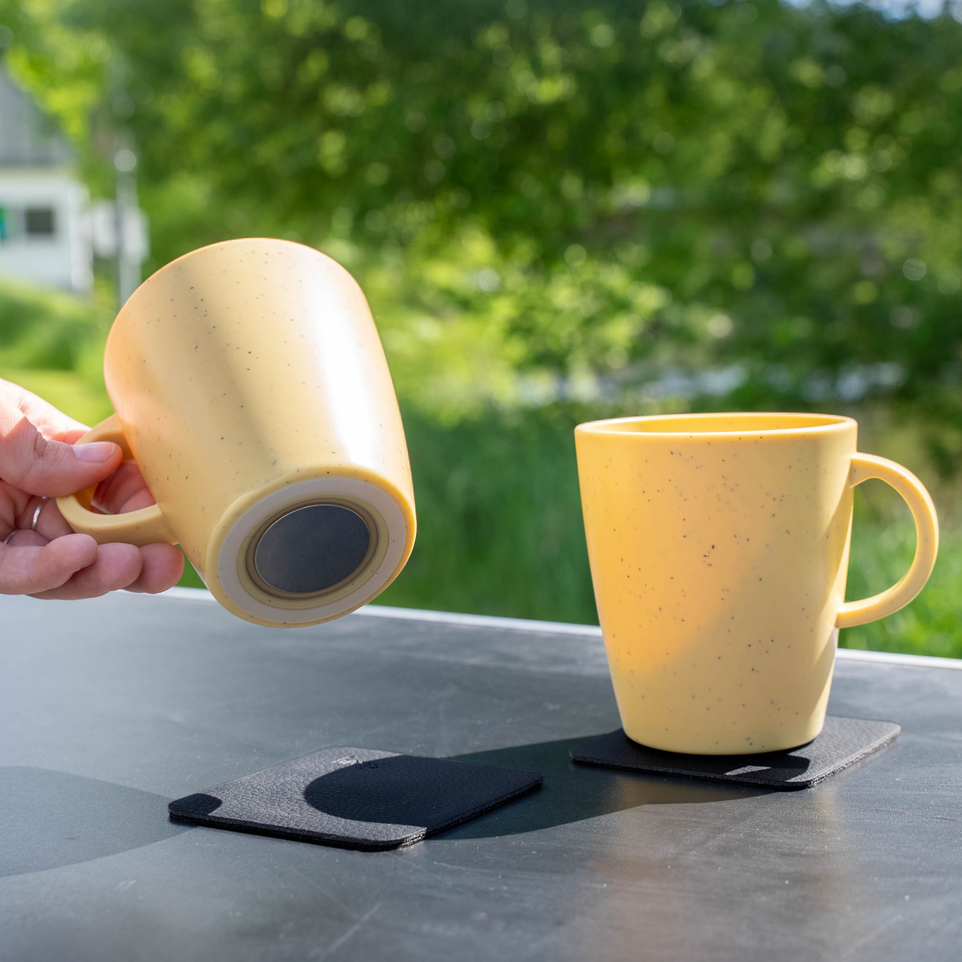 Tasses en plastique magnétiques yellow sur la table de camping depuis le bas