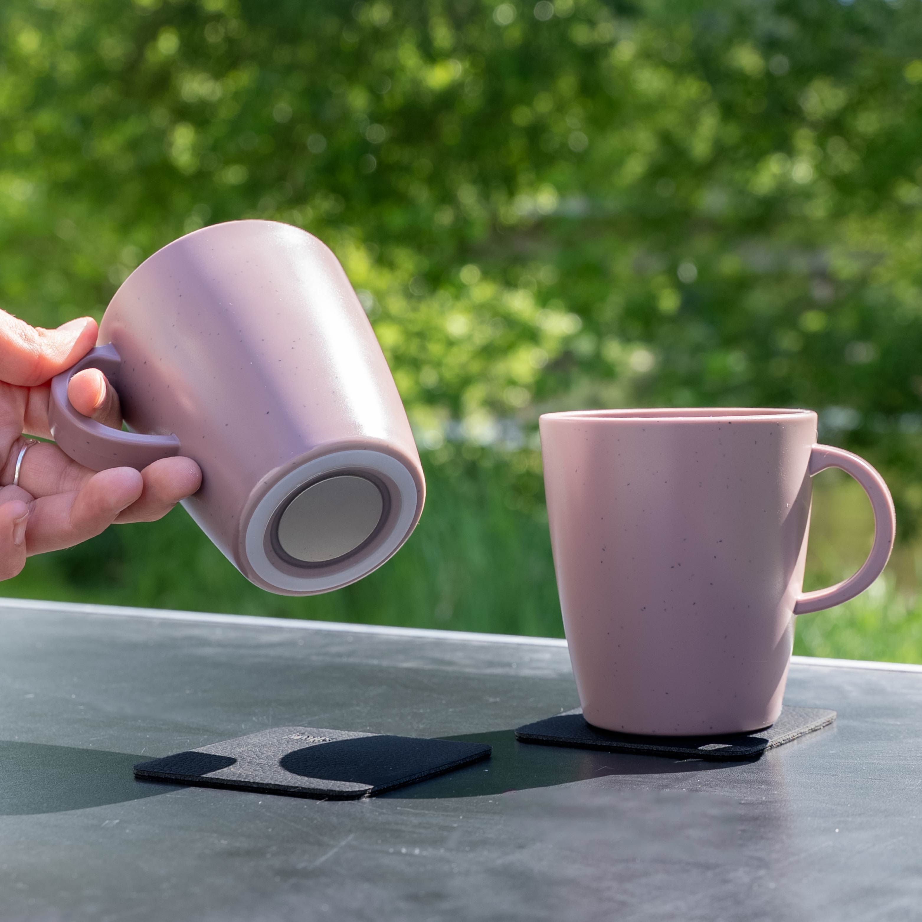 Tasses en plastique magnétiques rose sur table de camping vue d'en bas