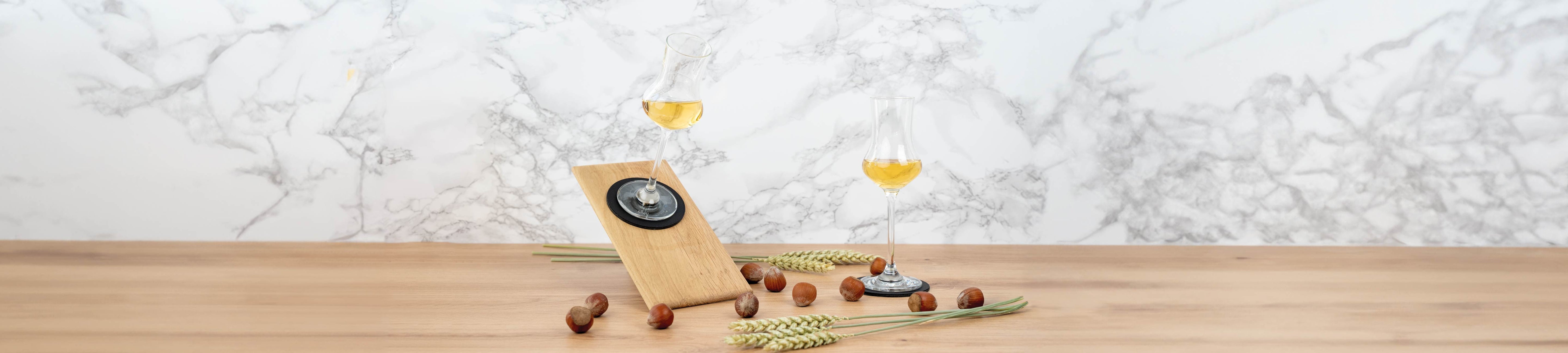 Immagine di testata con bicchieri di cristallo da liquore appoggiati su tappetini inclinati