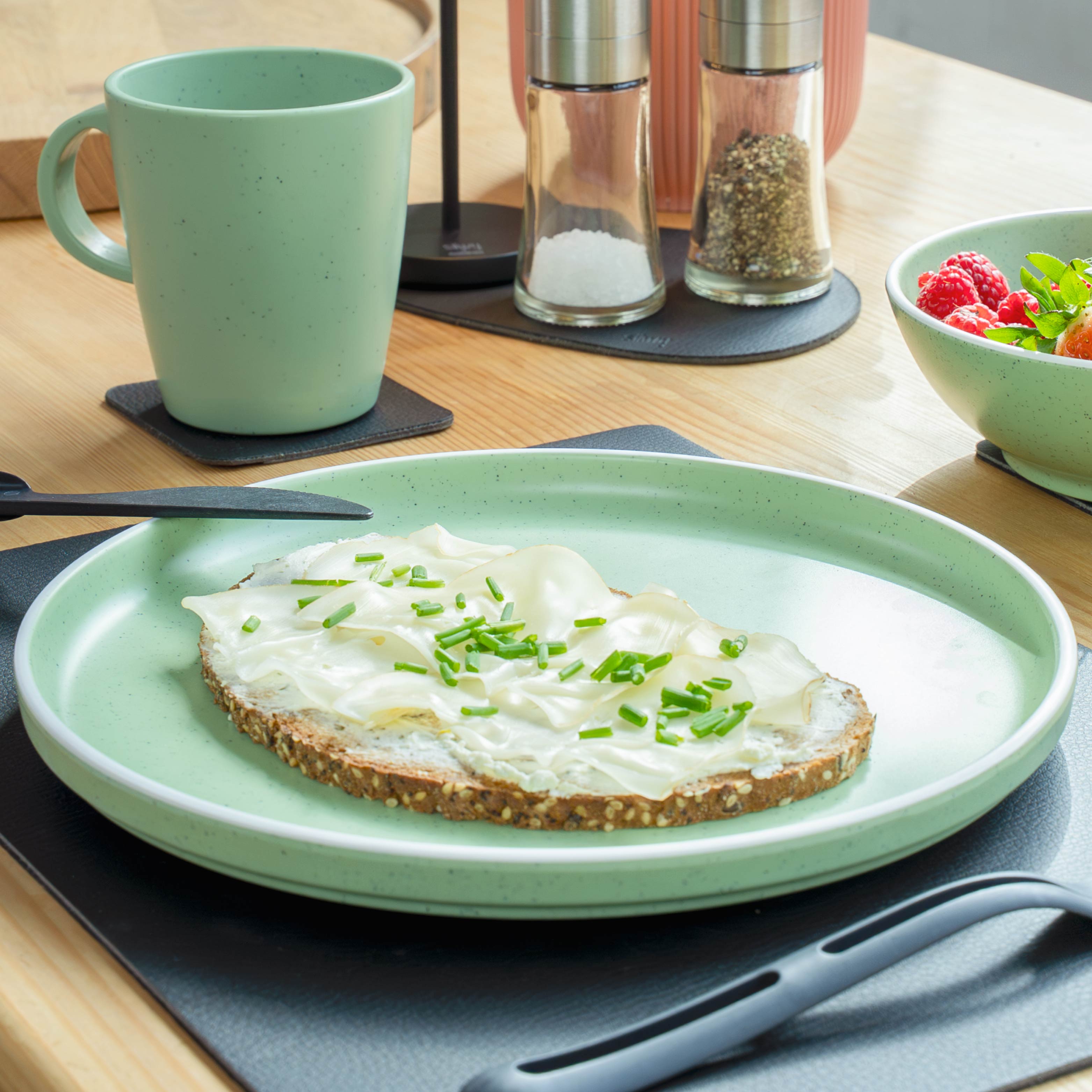Set di stoviglie in plastica Green su tappetino in ambiente di cucina