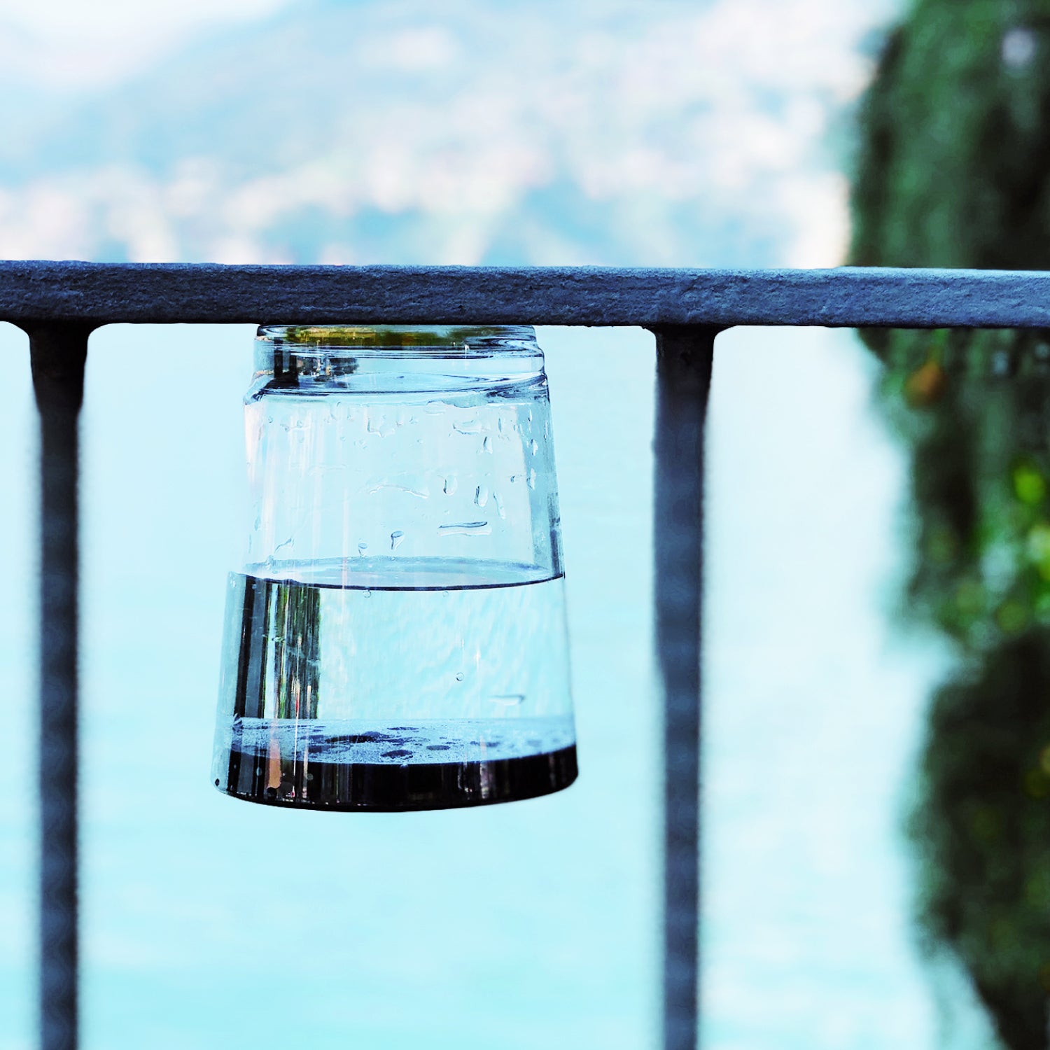 Classic bicchiere magnetico, riempito d'acqua e fissato a testa in giù su un ponte di metallo. 