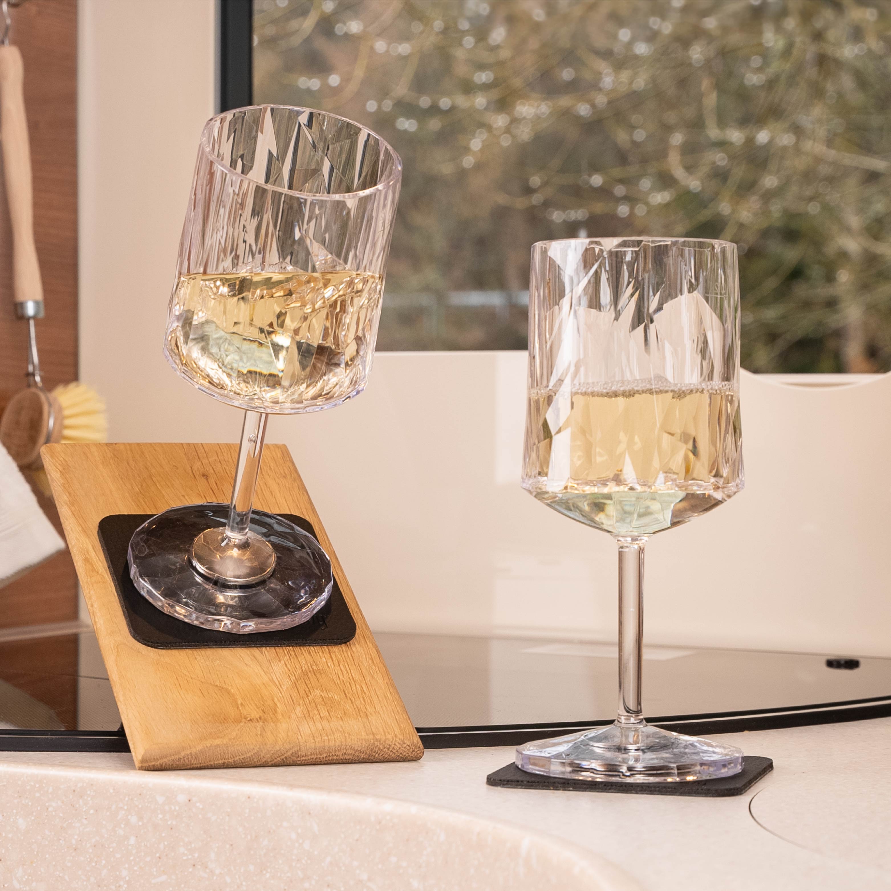 Bicchieri di vino in plastica magnetica posizionati su un cuscinetto in posizione inclinata in un camper